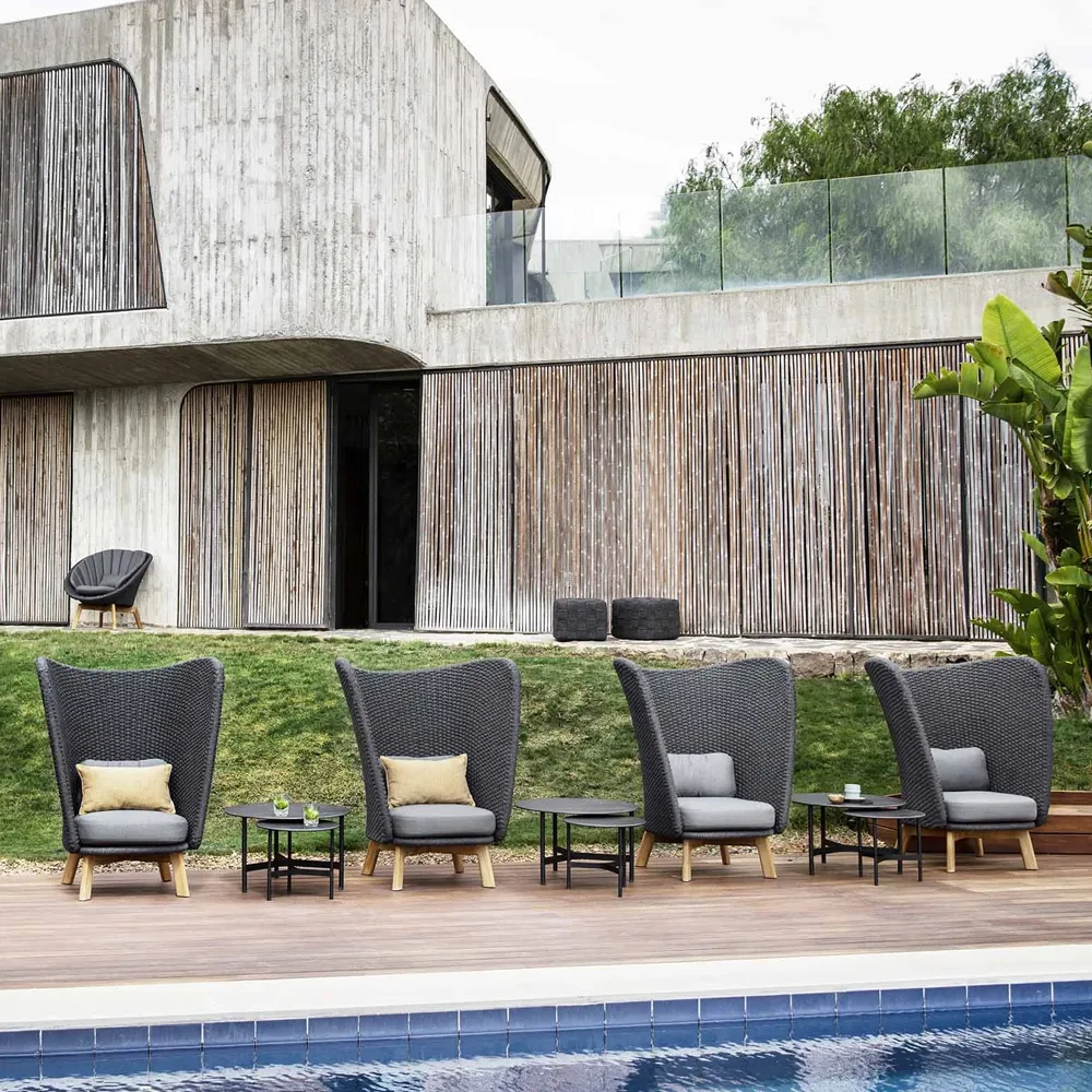 Butaca Lounge Peacock con respaldo alto, Cane-Line Natté dark grey, incl. cojines grises, patas de teca Cane-line