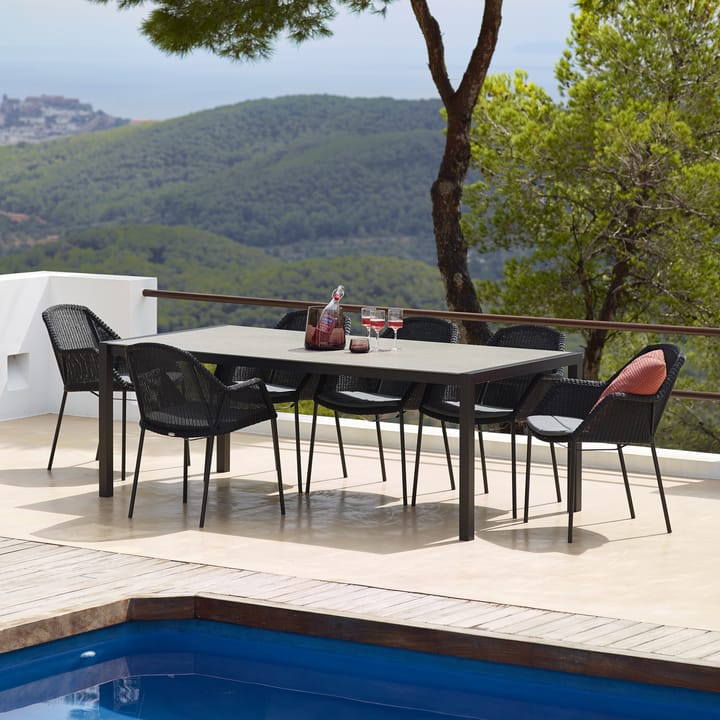 Silla con reposabrazos apilable Breeze weave, Black Cane-line