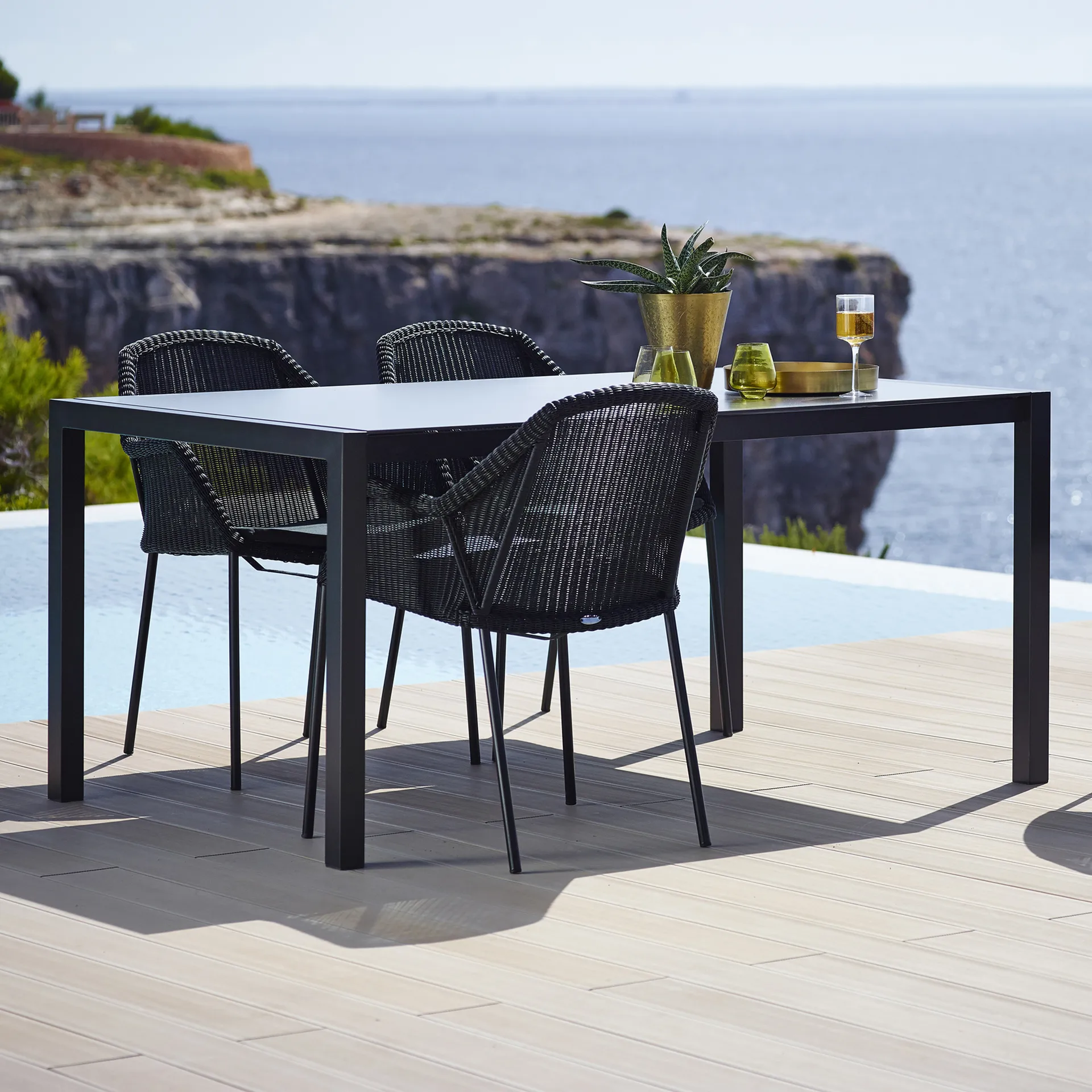 Silla con reposabrazos apilable Breeze weave, Black Cane-line