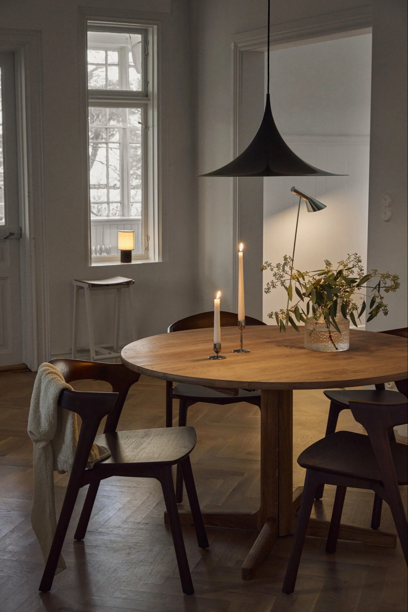 Ideas de iluminación en el comedor para resaltar la mesa. Aquí puedes ver la lámpara de techo Soft de Belid colgando sobre una mesa de comedor de madera.