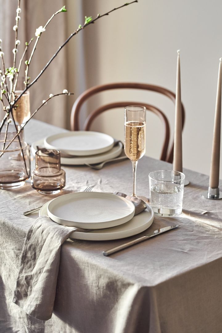 El mantel impoluto y las servilletas de lino constituyen la base perfecta para una mesa beige neutra y elegante. 