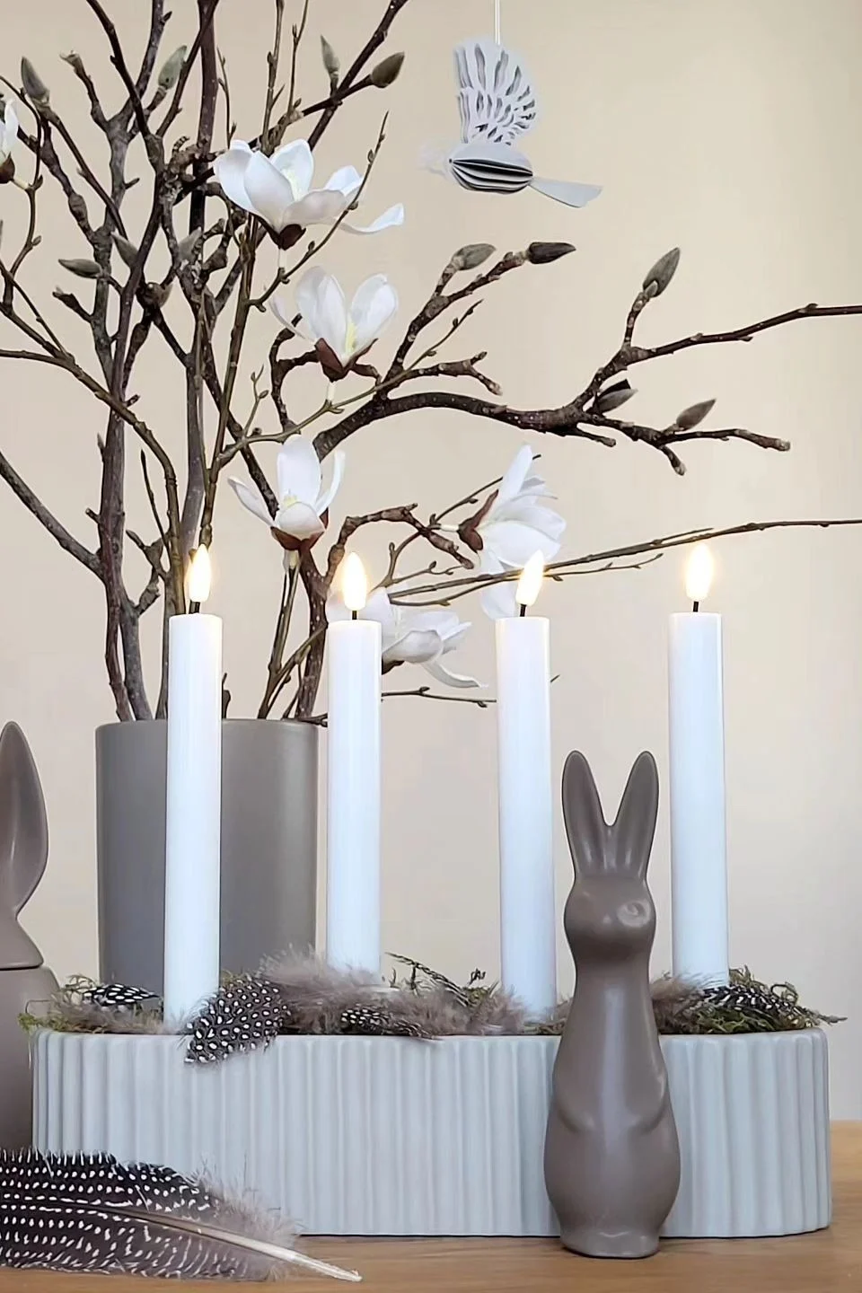 Decoración de Pascua: el simpático conejo en color Dust de DBKD se sitúa delante de un portavelas en @despina2014, con un arbusto de Pascua detrás.