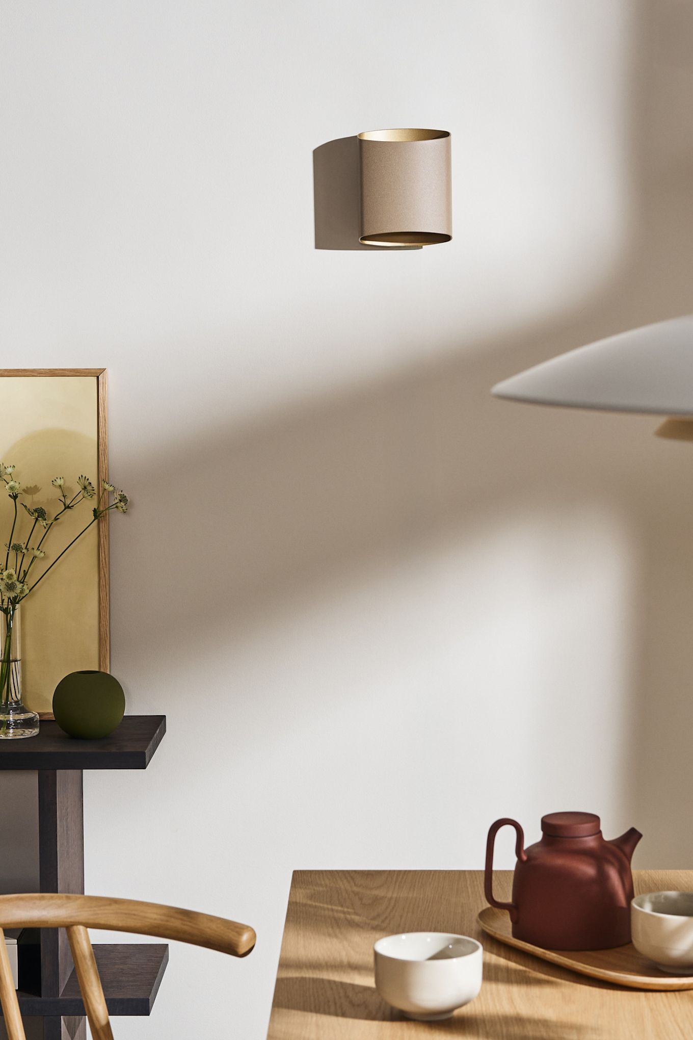 Coloca tus ideas de iluminación para el comedor, como la lámpara de pared Sinne de Belid, vista aquí en beige sobre la pared de un comedor.