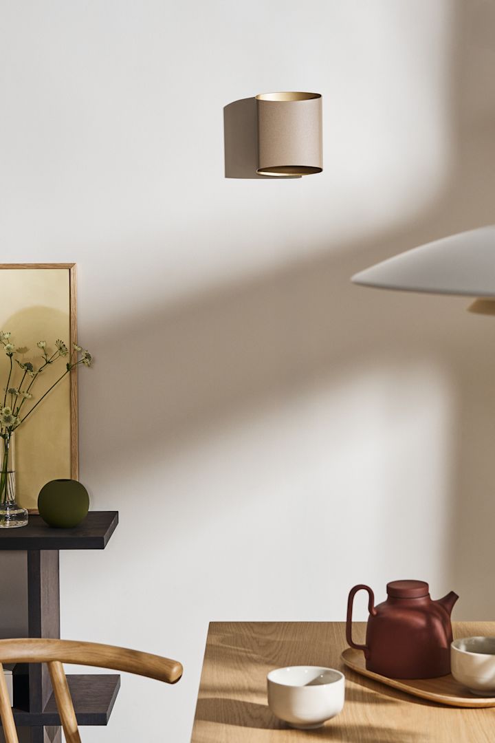 Coloca tus ideas de iluminación para el comedor, como la lámpara de pared Sinne de Belid, vista aquí en beige sobre la pared de un comedor.