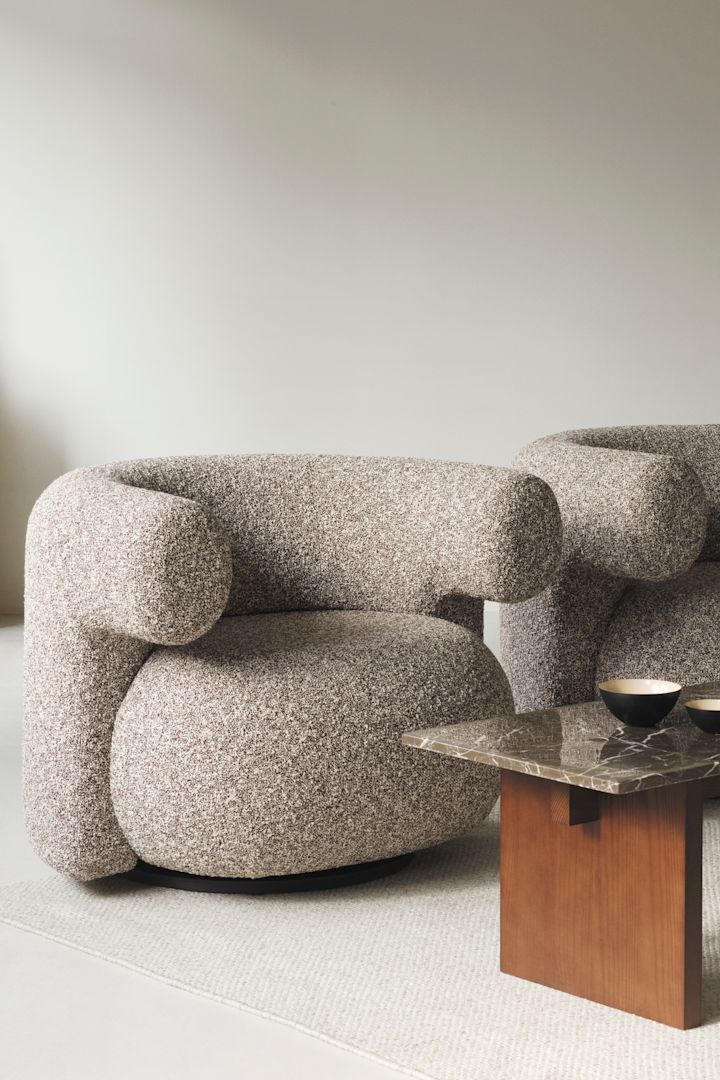 El robusto y macizo sillón Burra de Normann Copenhagen, aquí con una mesa de centro de madera con tablero de granito, ambos perfectos según las tendencias de interior de otoño de 2024 y con un diseño macizo.
