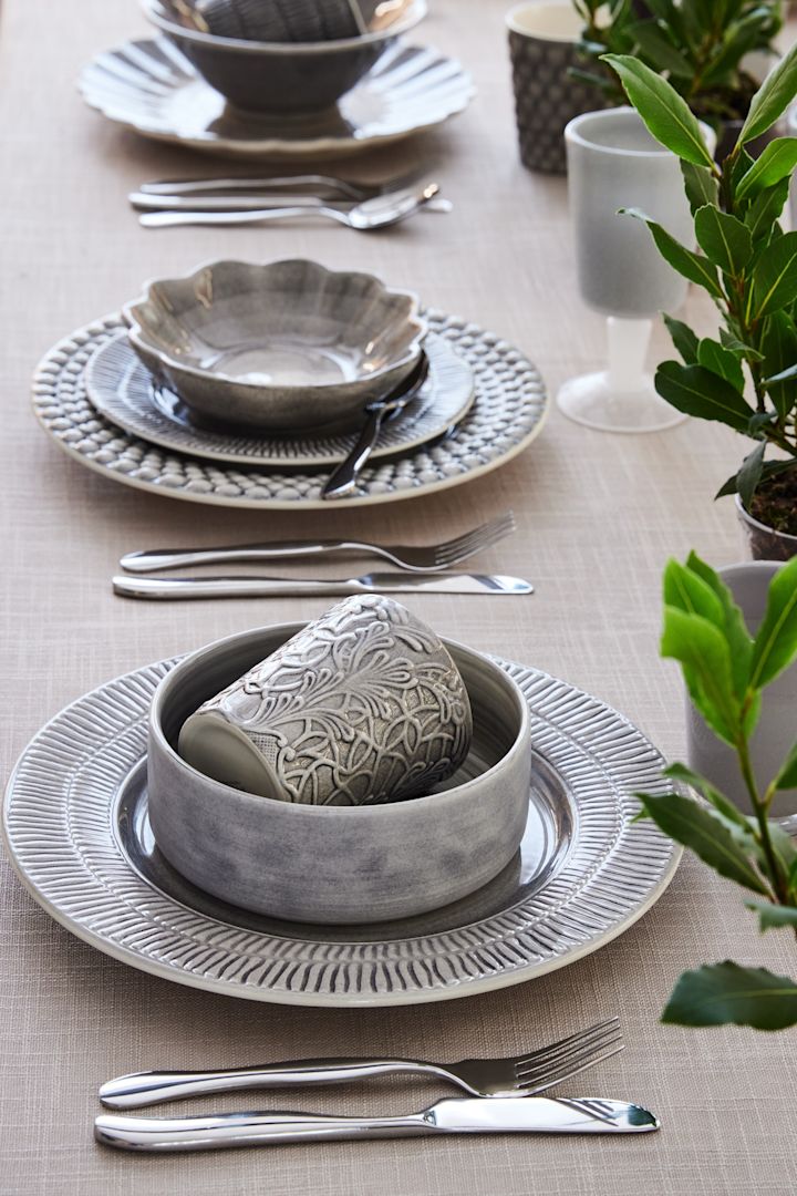 Una mesa puestat con vajilla gris de las colecciones Stripes, MSY y Lace de Mateus.