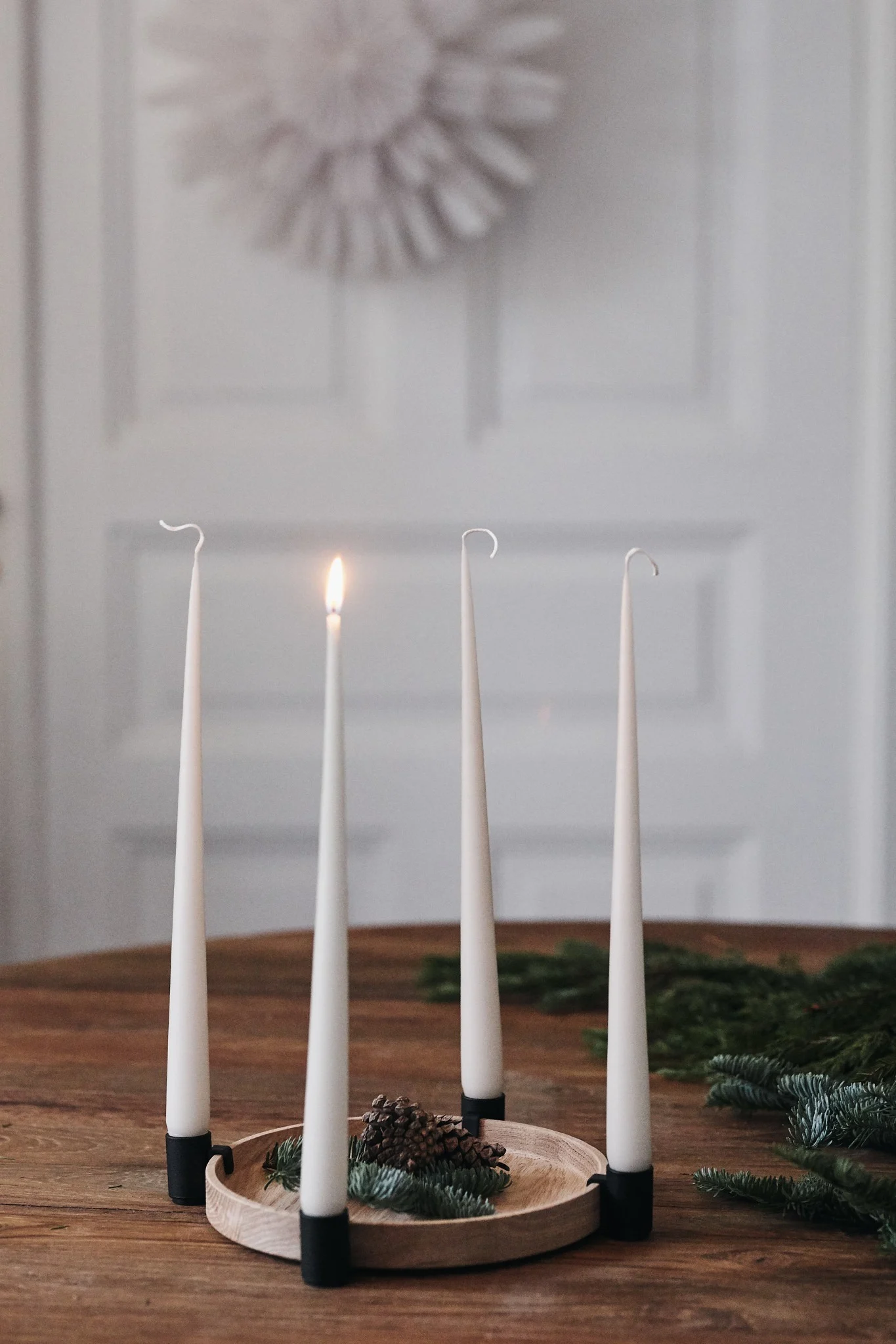 Encienda una vela por cada domingo de Adviento para ponerse en ambiente navideño. Aquí se ve el candelabro Luna de Applicata sobre una mesa.