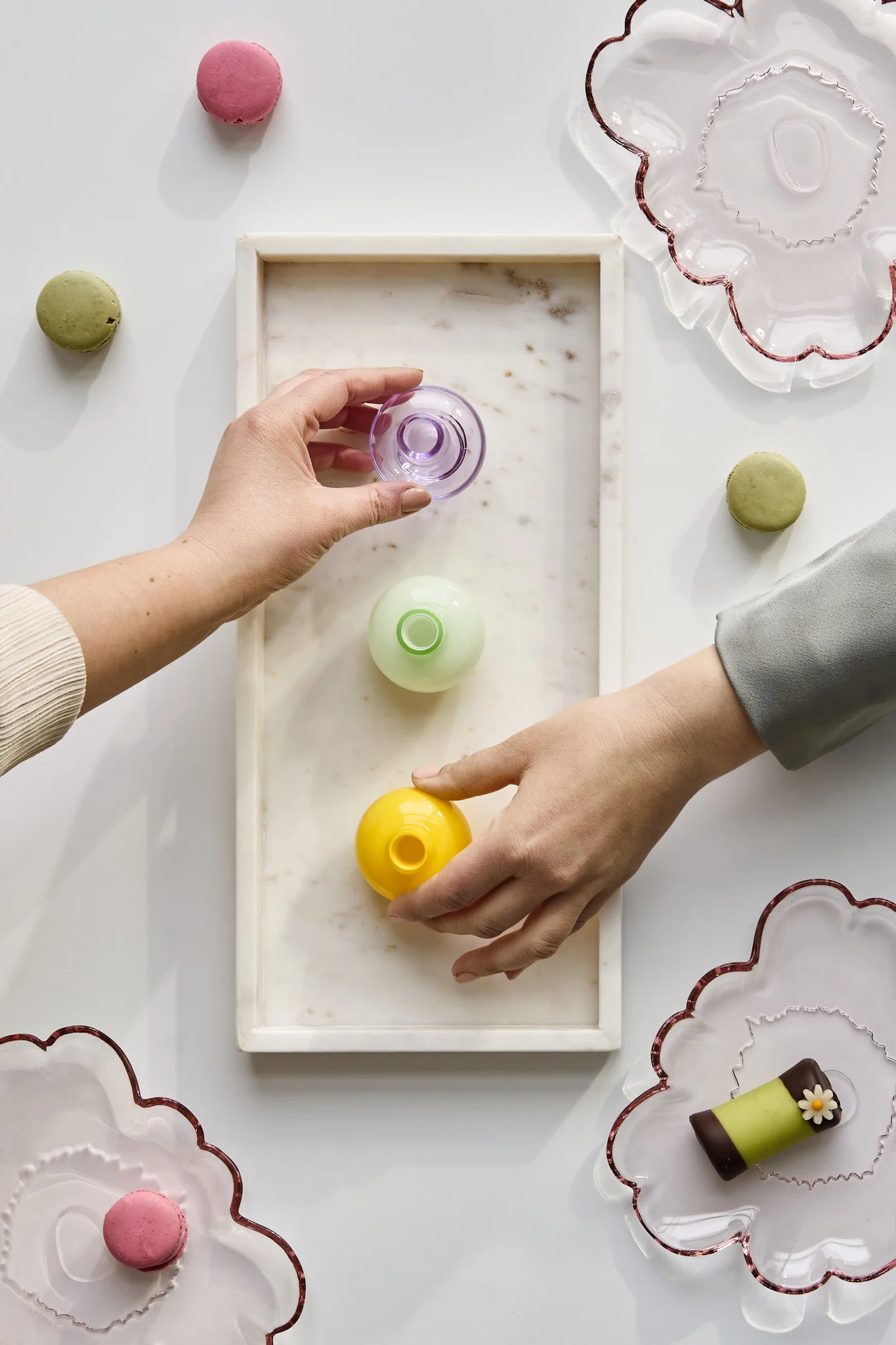 Las manos cogen jarrones de varios colores para llevárselos a casa como recuerdo de la fiesta. Descubre cómo organizar una fiesta con un ambiente inolvidable.