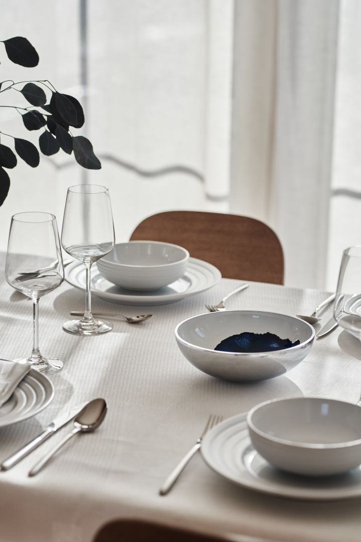 Una mesa blanca con porcelana de NJRD y servilletas y mantel de lino de Scandi Living. 
