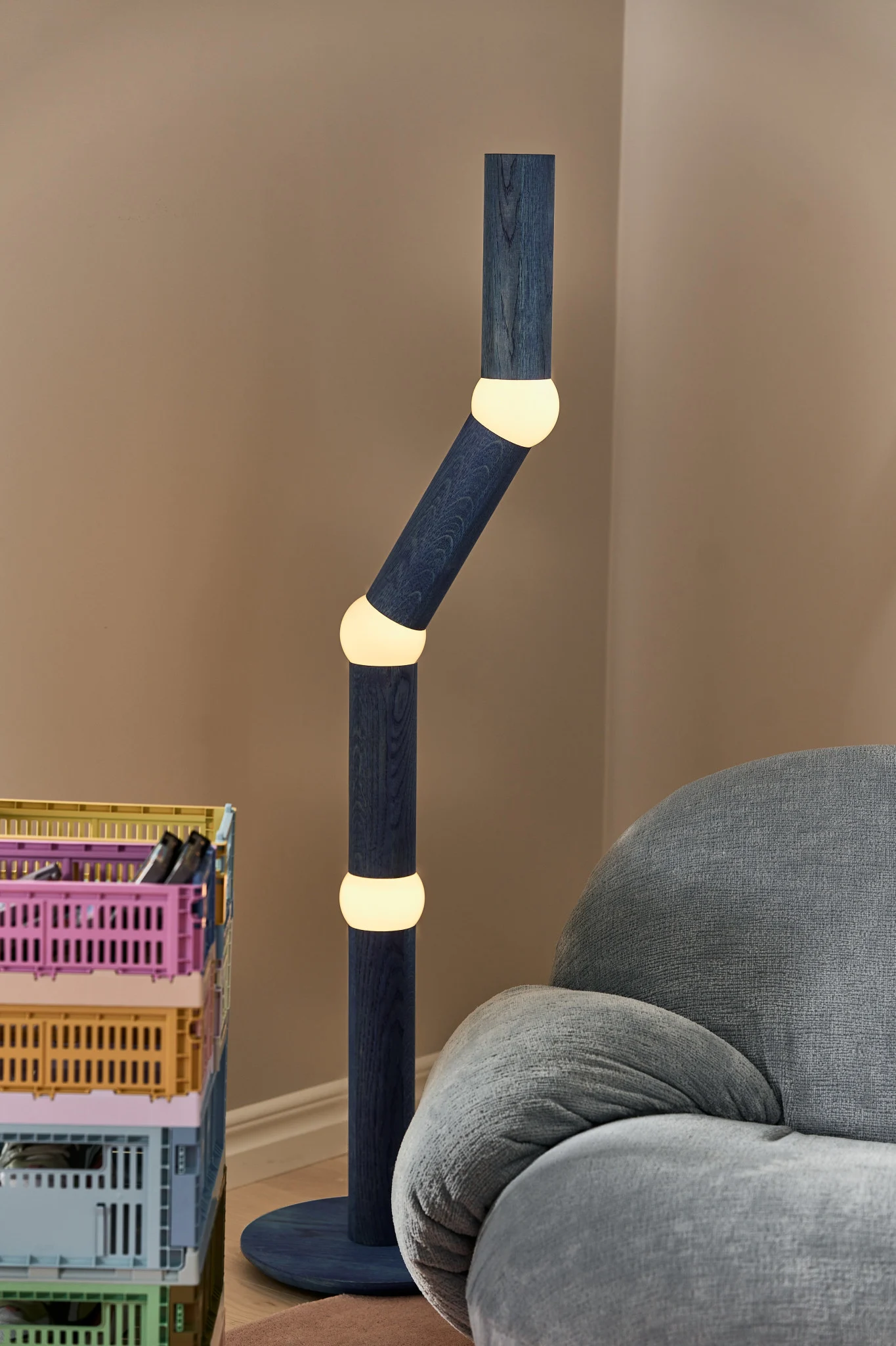 Iluminación moderna para todas las áreas del hogar. Aquí puedes ver una lámpara de pie Oblure azul con un diseño inusual en una sala de estar colorida.