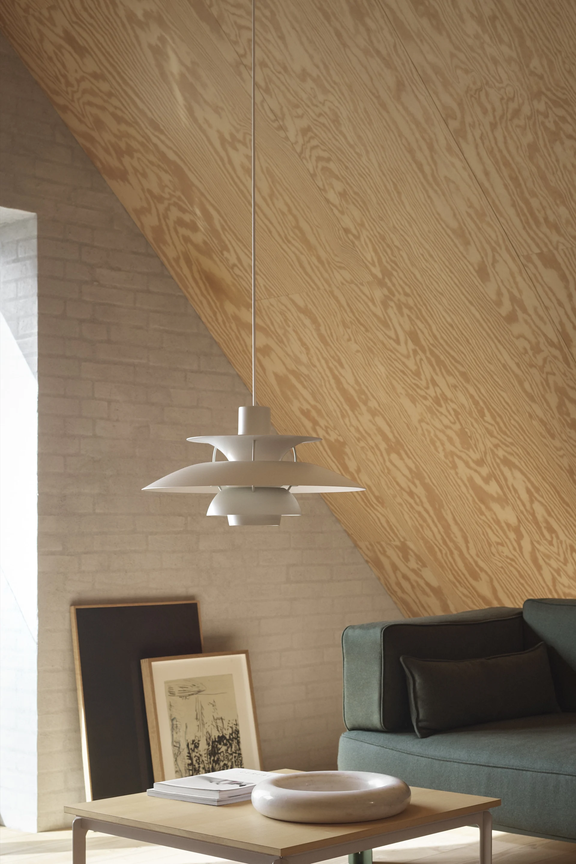 Lámparas escandinavas: La lámpara colgante PH 5 Mini de Louis Poulsen se encuentra en un salón decorado al estilo escandinavo.