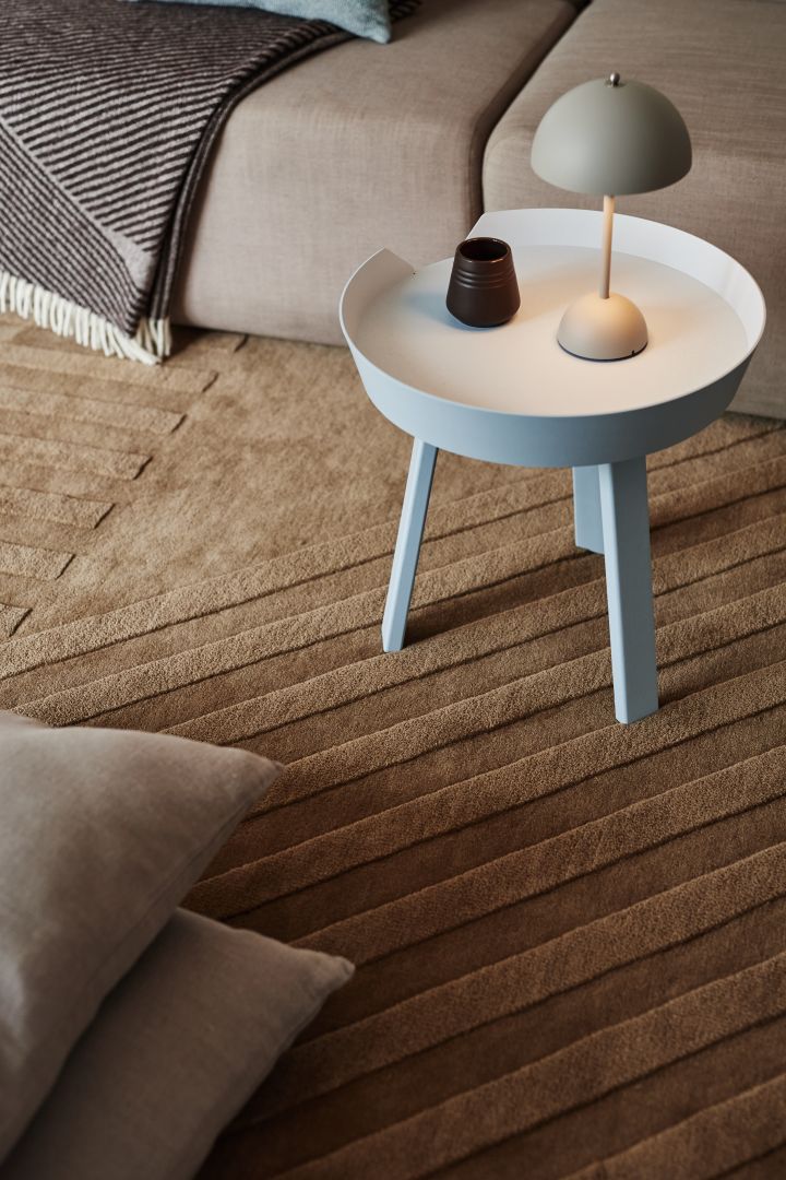 La alfombra de lana Levels Stripes beige de NJRD y la lámpara de mesa Flowerpot VP9 de &Tradition darán a tu hogar un toque acogedor.