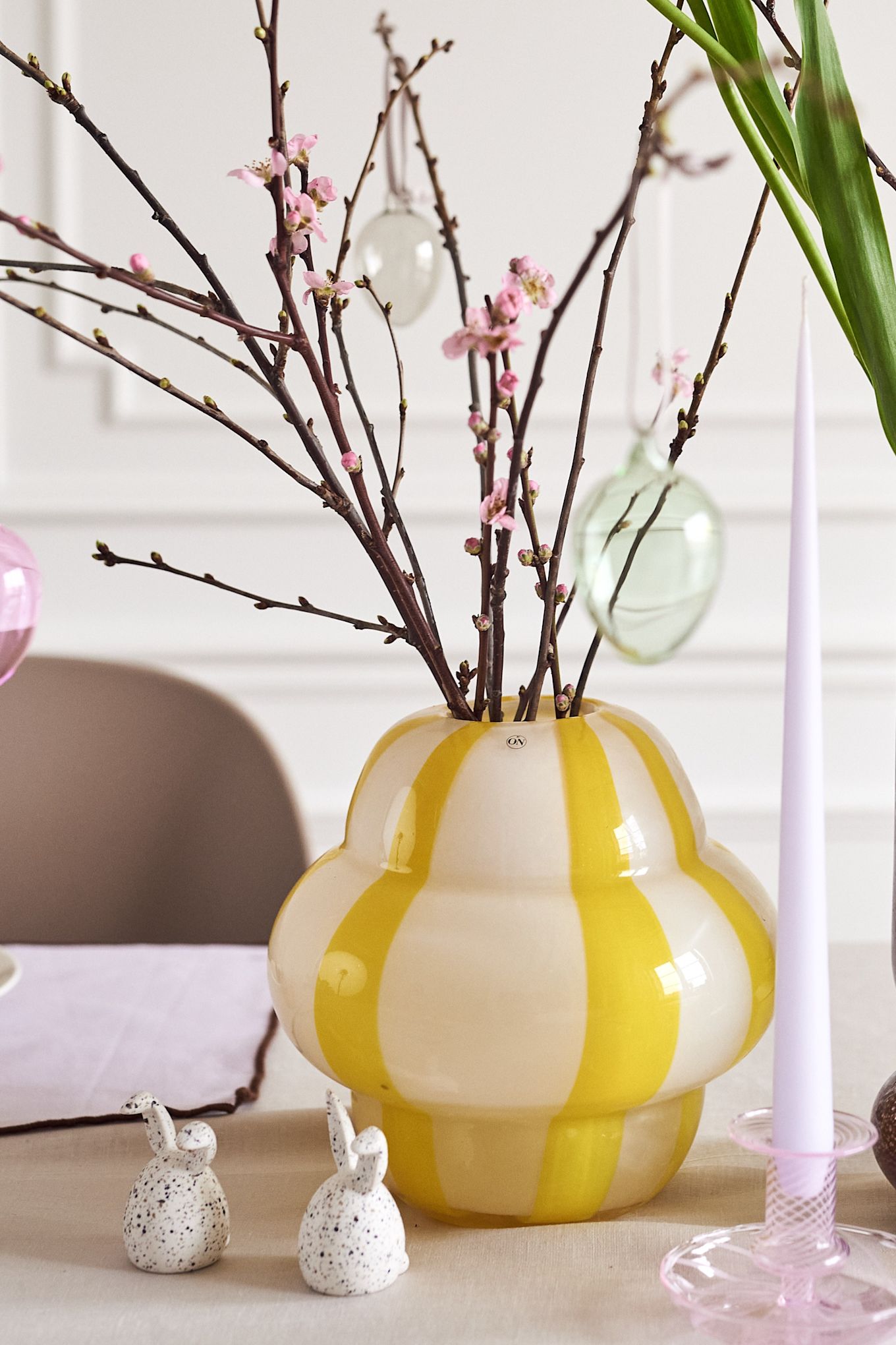 Crea un árbol de Pascua en casa con jarrones coloridos, como el jarrón Curlie en amarillo de By On o el jarrón Dorit de Broste Copenhagen.
