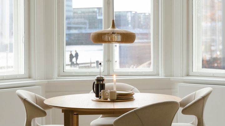 Lagom: un comedor minimalista con muchas ventanas y la lámpara de techo Clava Dine Wood de Umage.