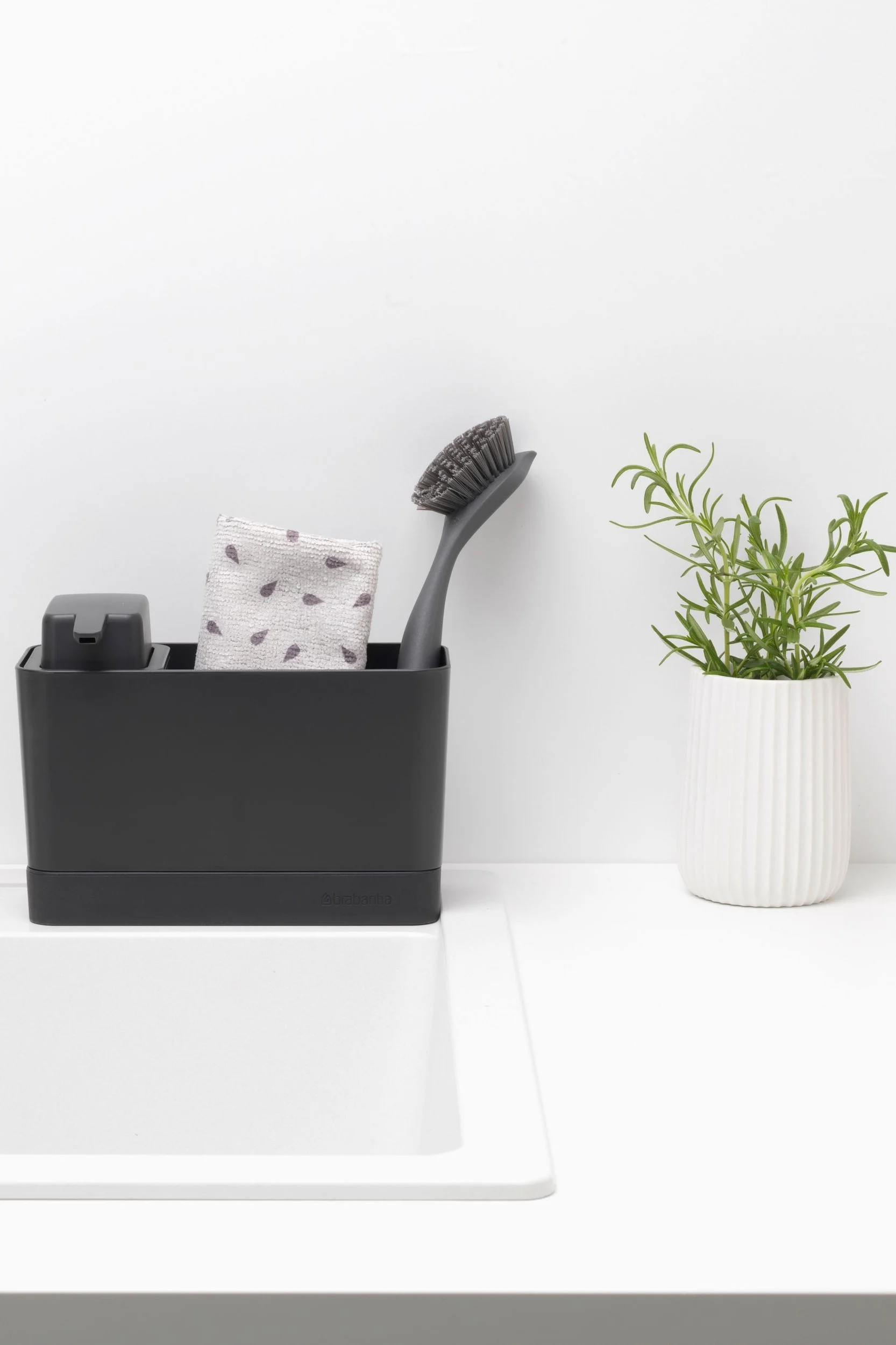 Limpia tu sartén con el organizador para fregadero de Brabantia, que incluye un dispensador de jabón, un trapito y un cepillo para fregar platos.