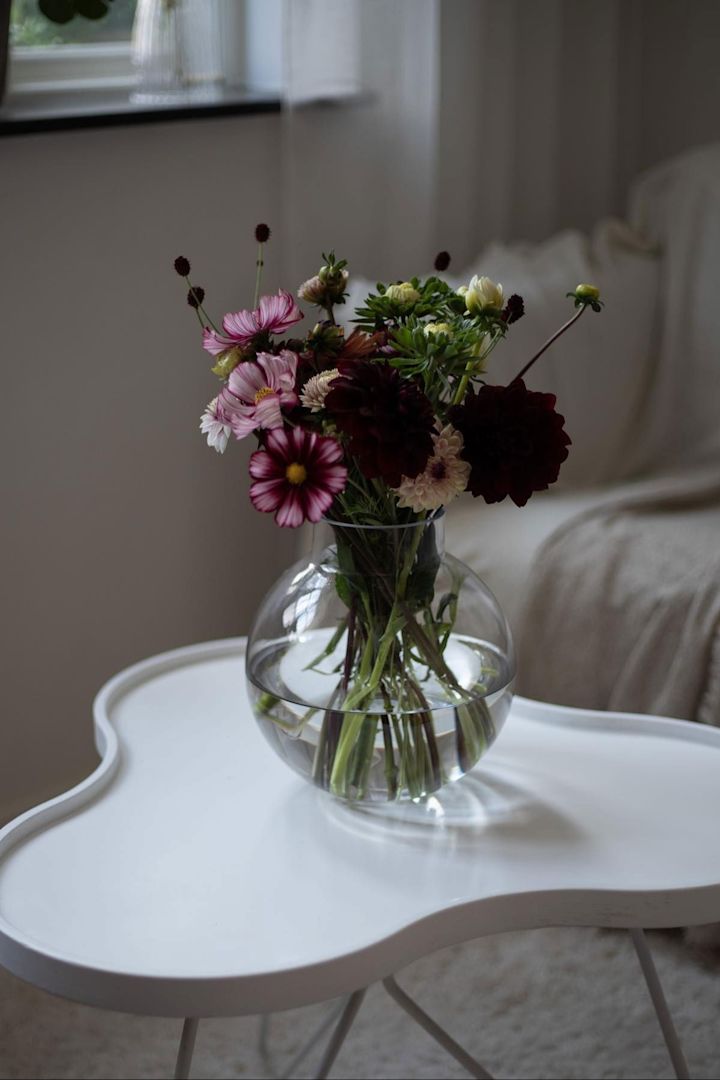 El jarrón de cristal de Ernst, que se ve aquí en la mesa Flower de Swedese de la casa de @norregardnr9, es un regalo estupendo para el Día de la Madre junto con un precioso ramo rosa y morado.