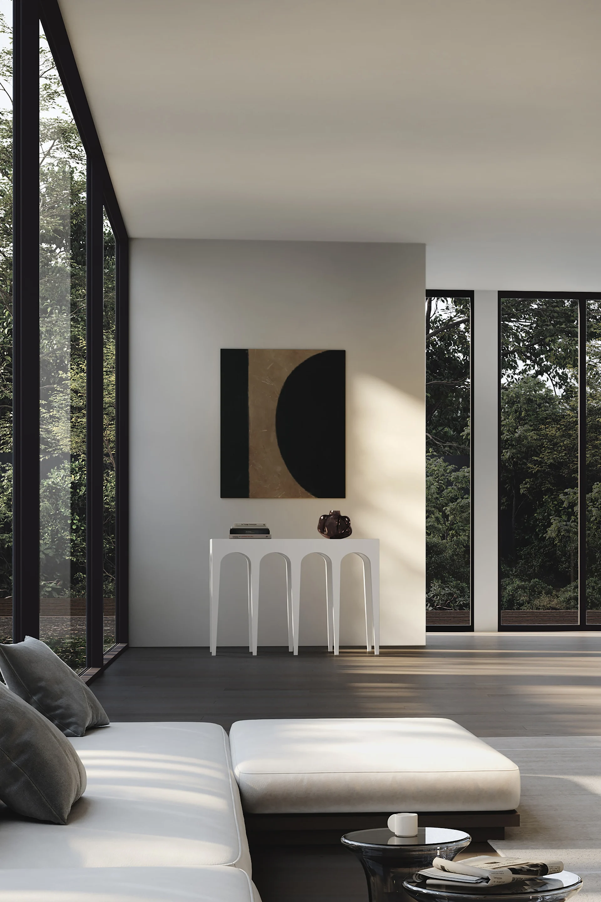 Una sala de estar moderna con un sofá blanco, una mesa consola bajo una pintura abstracta y grandes ventanales con árboles verdes.