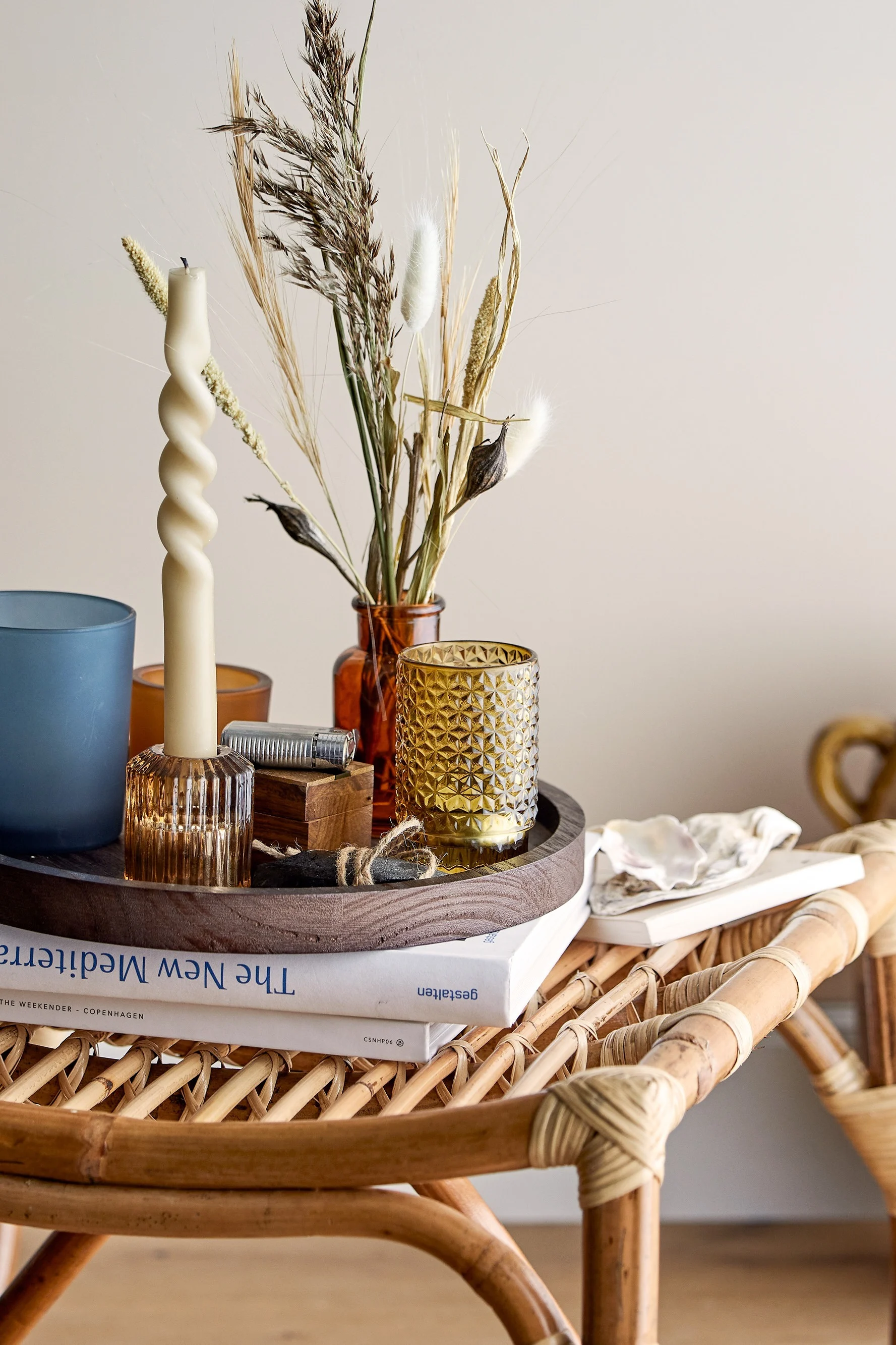 En una mesa de centro de estilo boho, hay una bandeja con portavelas de Bloomingville.