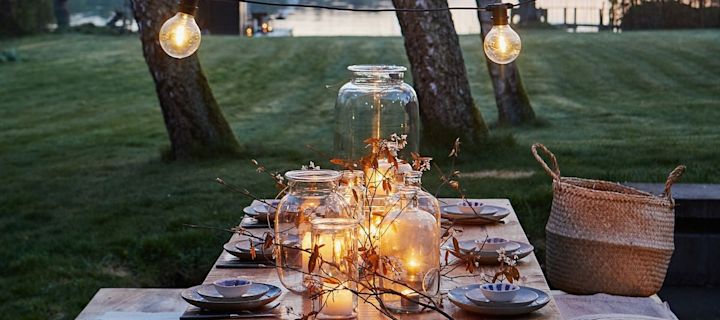 Crea un ambiente acogedor para tu fiesta en el jardín y decora la mesa con numerosos farolillos de exterior y portavelas.