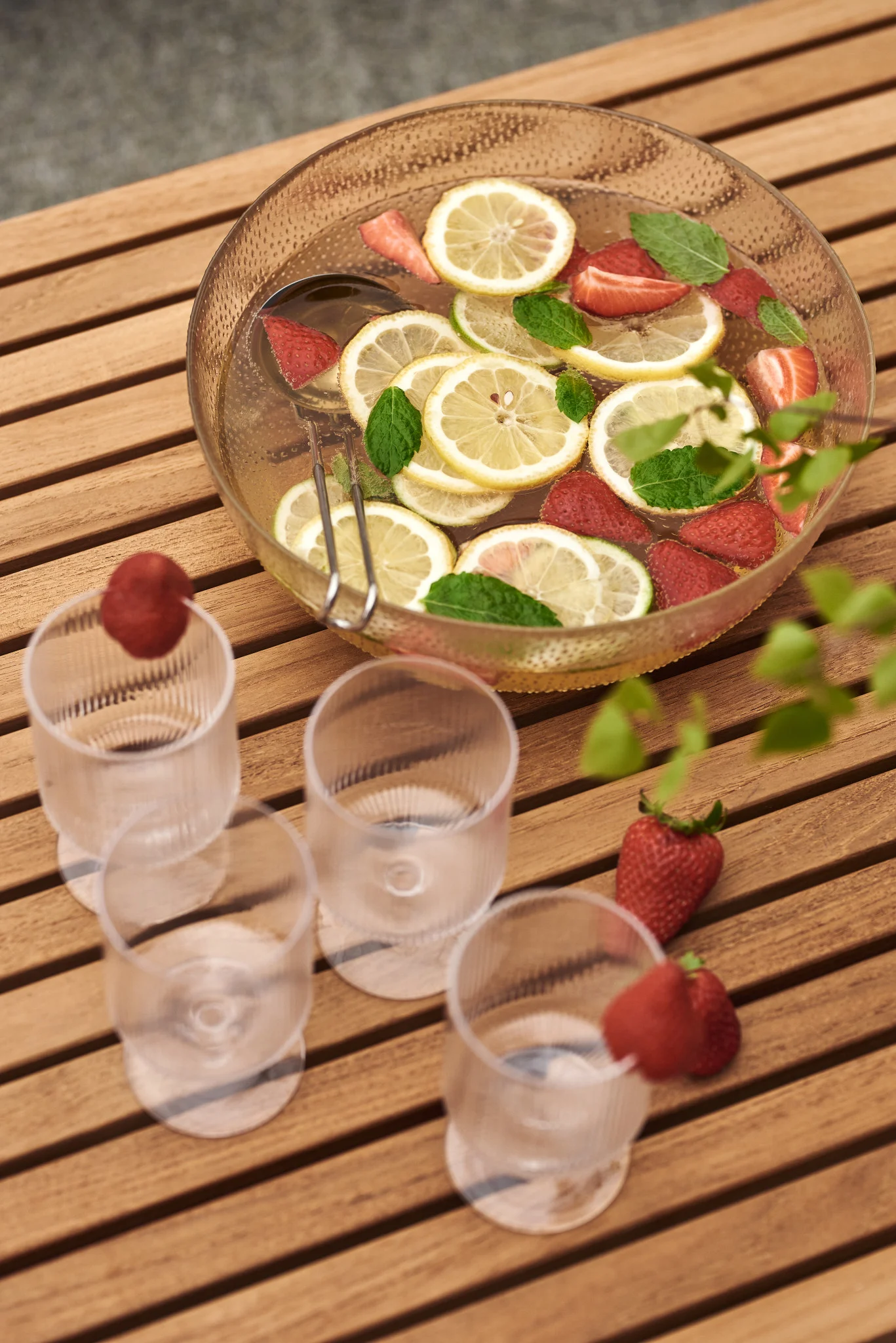 Una sencilla bebida veraniega: aquí puedes ver un cuenco de cristal lleno de limones y fresas.