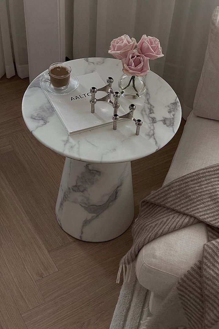 Regalos para el Día de la Madre: Los elegantes portavelas plateados STOFF sobre una mesa auxiliar de mármol, junto a una taza de café y un pequeño jarrón de rosas en casa de @helenas.hem.