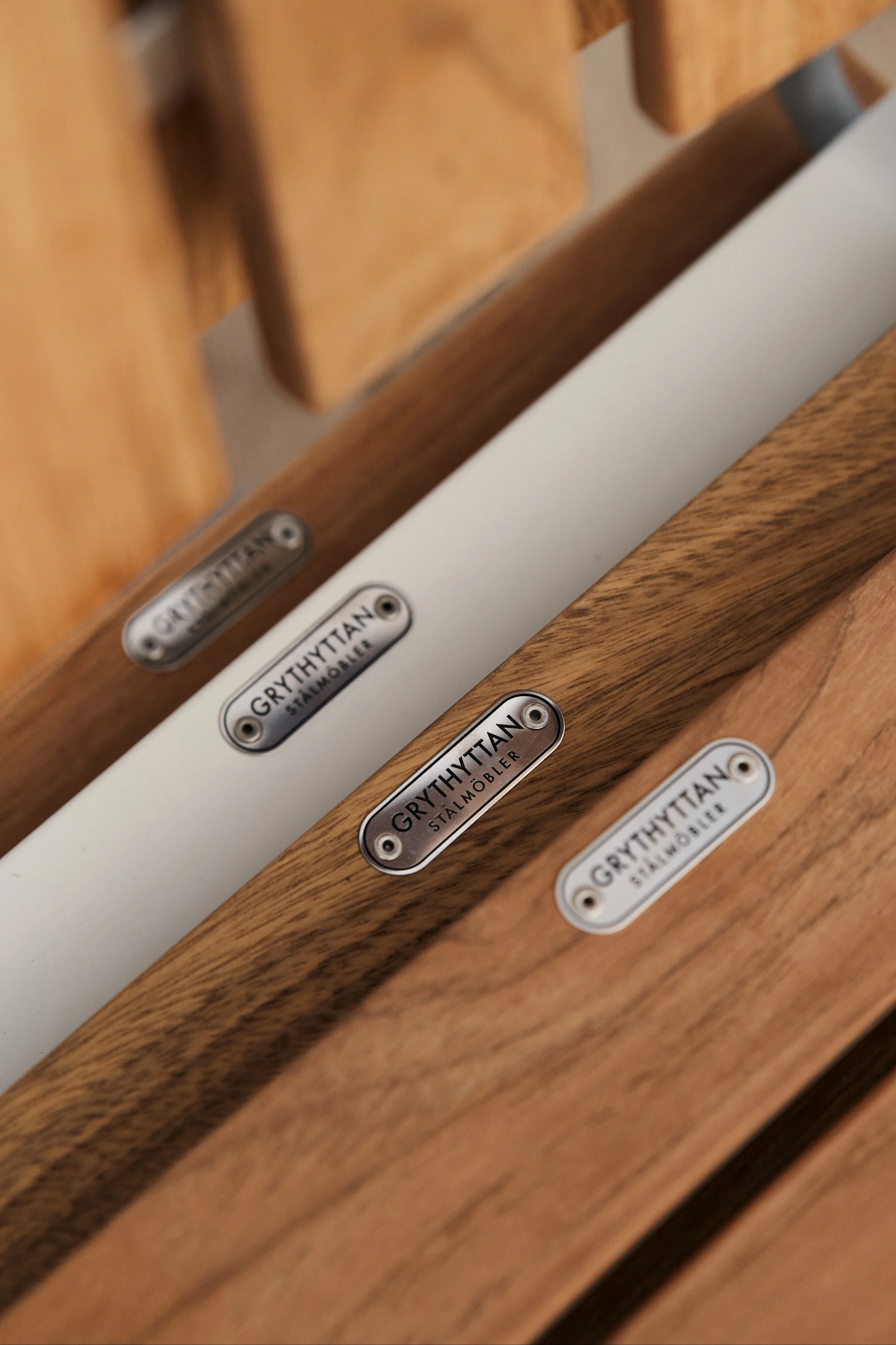 La silla A2 de Grythyttan Stålmöbler es un icono entre los muebles de exterior en teca, aquí una imagen de detalle del asiento donde el logo en acero se coloca como un bonito detalle.