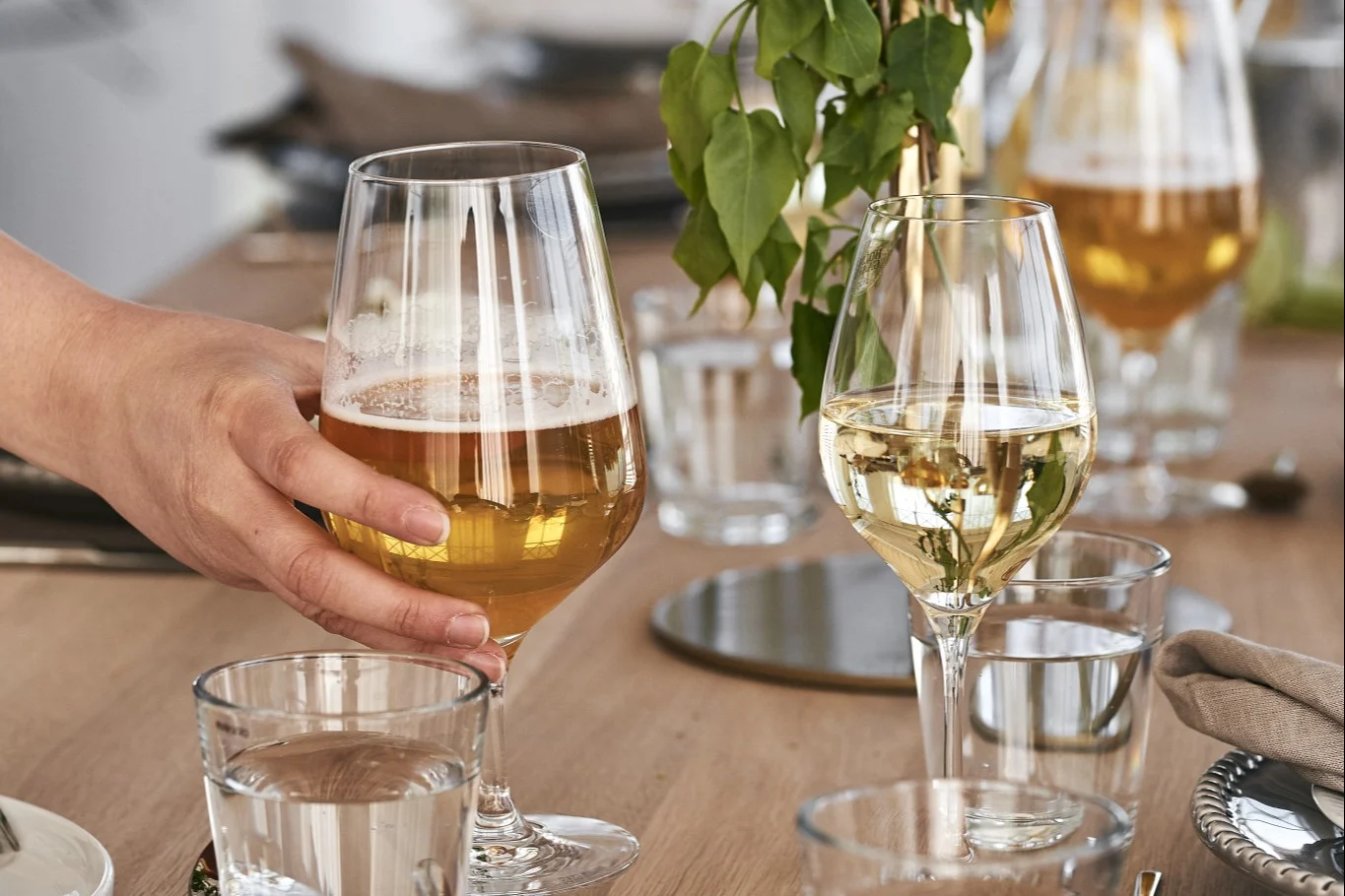 Cómo elegir el vaso de cerveza adecuado: aquí puede ver a alguien recogiendo el vaso de cerveza Cabernet de Holmgaard.