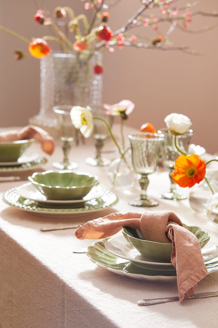 Aquí puedes ver una idea de mesa de Pascua en tonos verdes de Mateus, con platos verdes y servilletas de lino rosa.