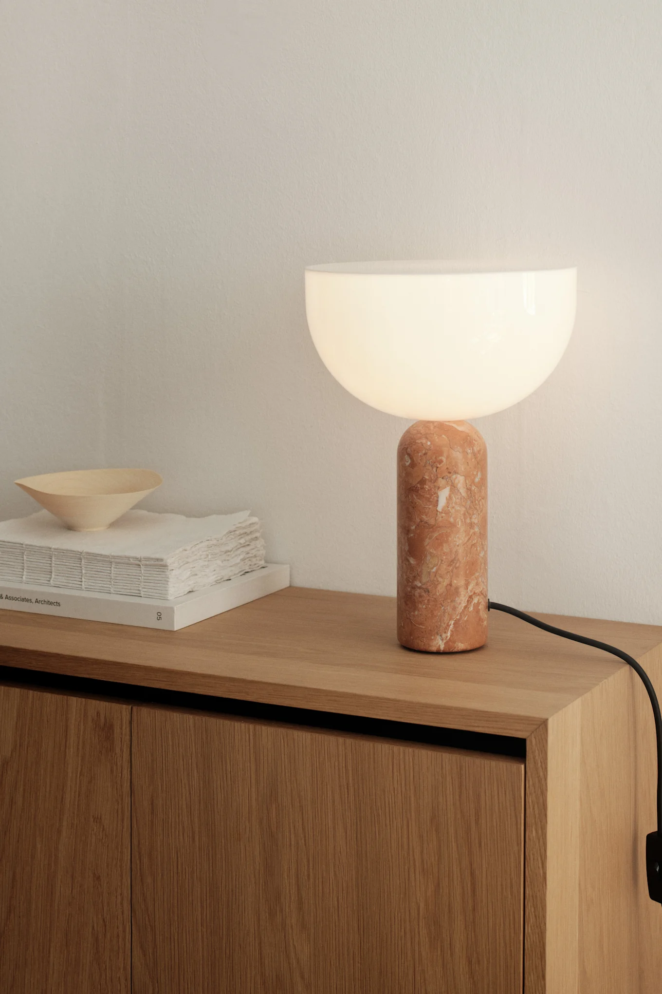Ideas de iluminación para el comedor. Aquí puedes ver la lámpara de mesa Picasso en beige de Belid sobre una mesa auxiliar.