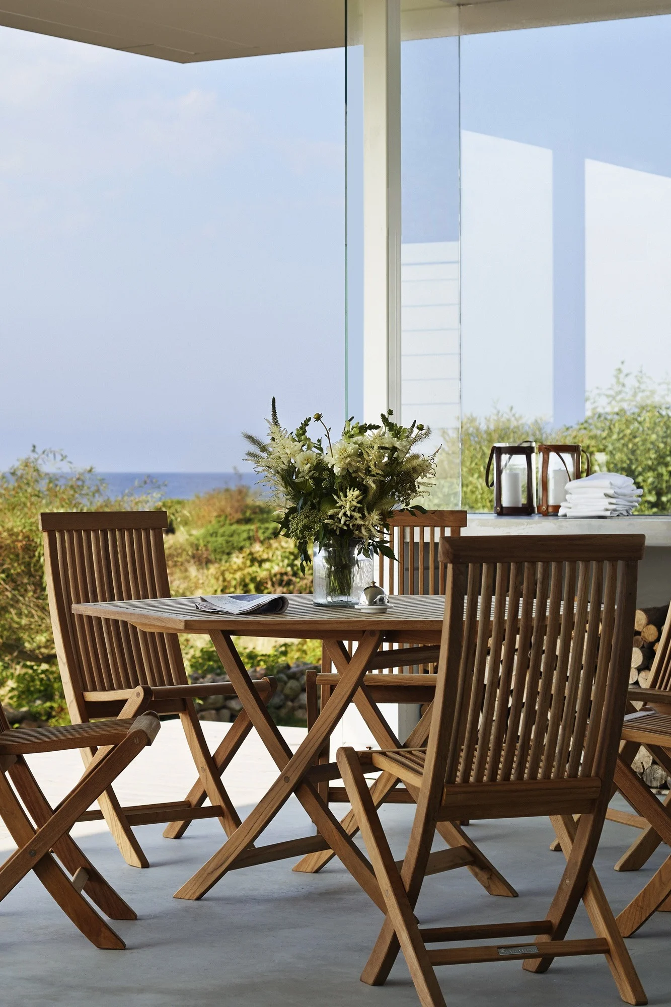 La teca es una de las tendencias en mobiliario de jardín para 2025. Aquí puedes ver la mesa y las sillas de la colección Viken de Skargaarden colocadas en una terraza.