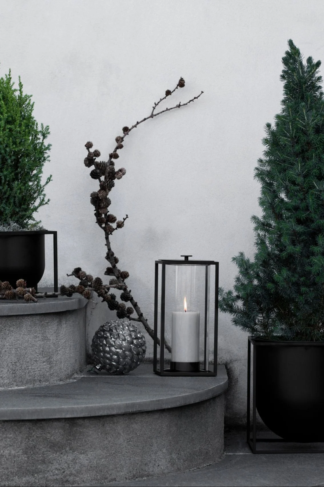 Embellece tu escalera exterior con faroles y portavelas para exterior, por ejemplo con el farol Light'In de Audo Copenhagen.