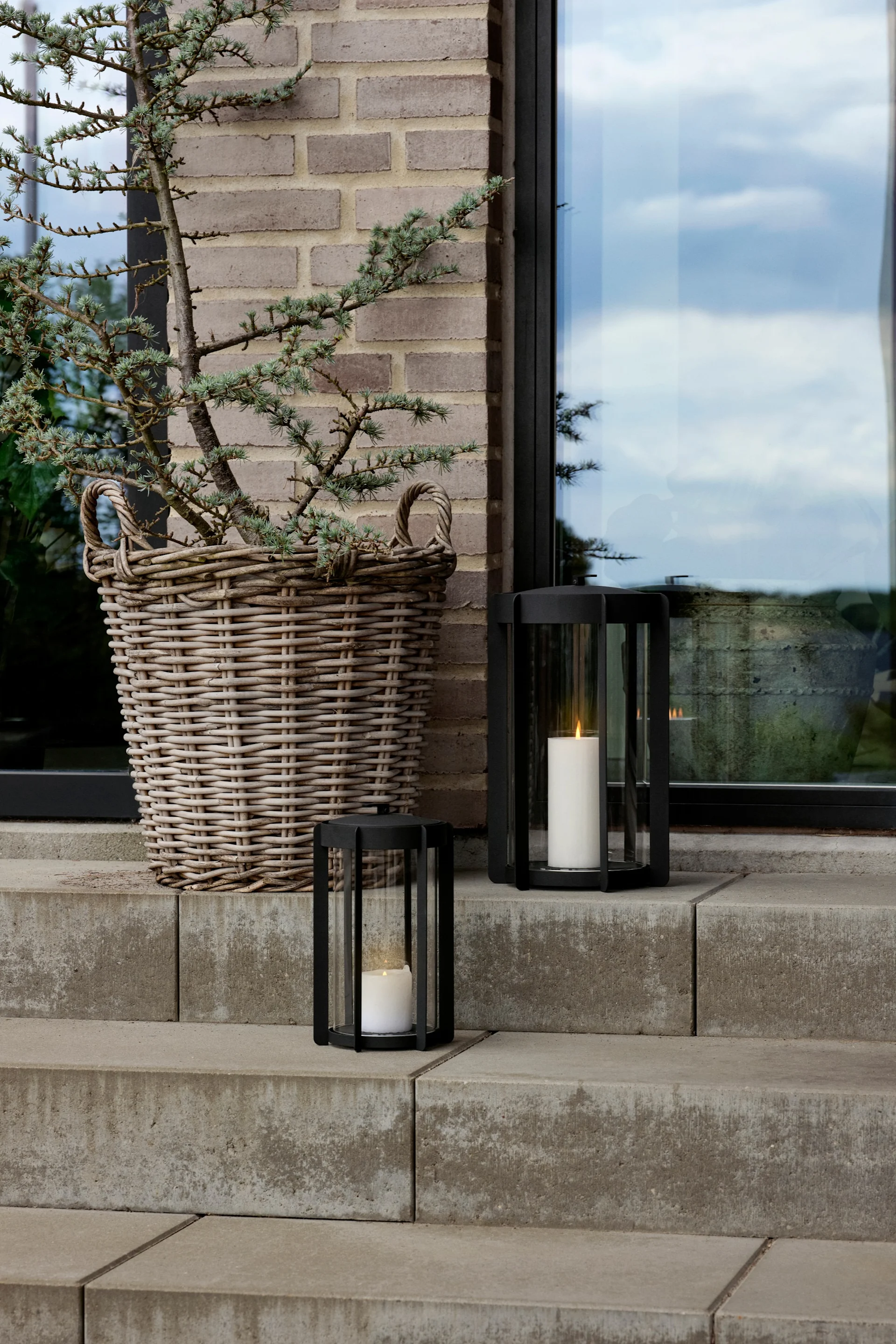 Embellece tu escalera exterior con faroles y portavelas para exterior, por ejemplo con el farol Light'In de Audo Copenhagen.