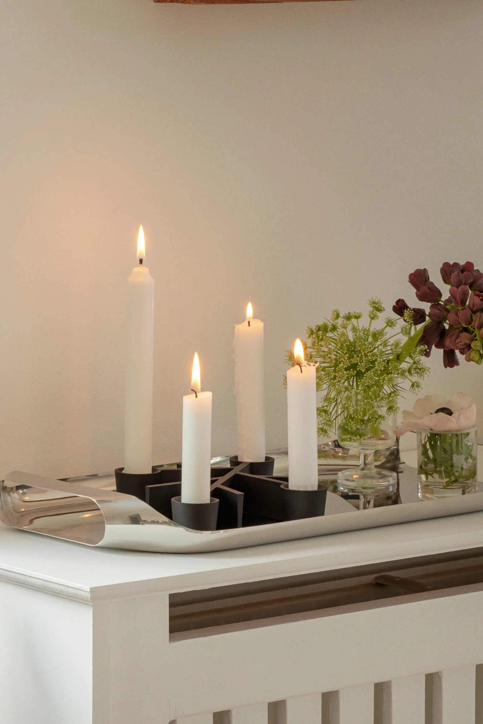 Sobre una cómoda se encuentra el portavelas Twig de Eva Solo, decorado con motivos navideños.