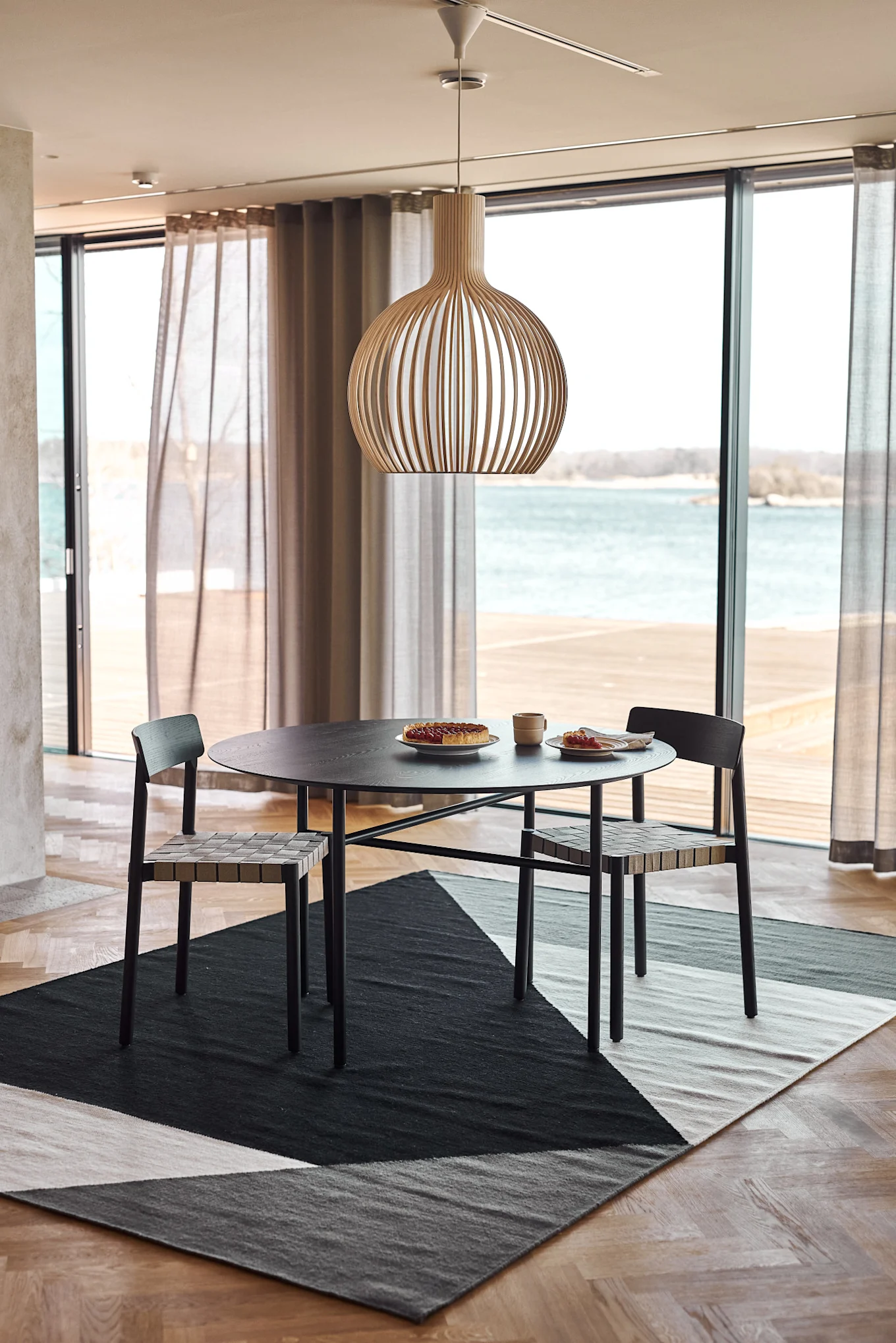 Alfombras para el comedor: la alfombra Kelim Stripes Blocks de NJRD está colocada en un comedor escandinavo lleno de luz natural.