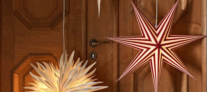Aquí puedes ver un nuevo modelo entre las estrellas navideñas: las estrellas de patrón rojo y blanco de la colección Bare de Scandi Living, colgando en una puerta.