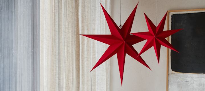 Aquí puedes ver un nuevo modelo entre las estrellas navideñas: las estrellas de patrón rojo y blanco de la colección Bare de Scandi Living, colgando en una puerta.