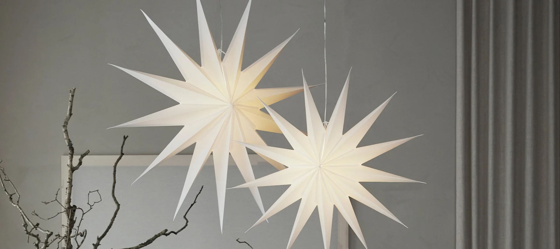 Aquí puedes ver un nuevo modelo entre las estrellas navideñas: las estrellas de patrón rojo y blanco de la colección Bare de Scandi Living, colgando en una puerta.