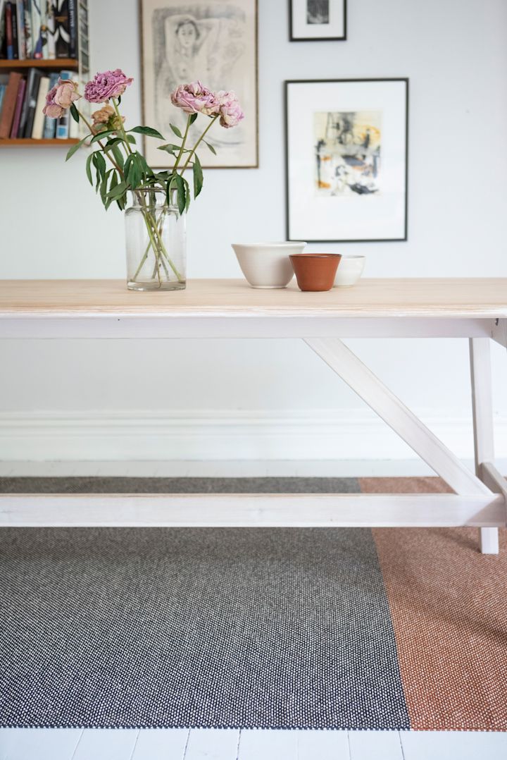 Alfombra para el pasillo: la alfombra Moor de Brita Sweden está colocada bajo una mesa, con numerosas imágenes decorando la pared.