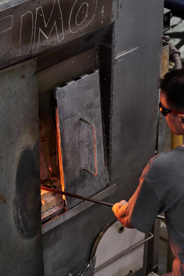 Un hombre introduciendo vidrio en el horno de la fábrica de Iittala, en Finlandia.