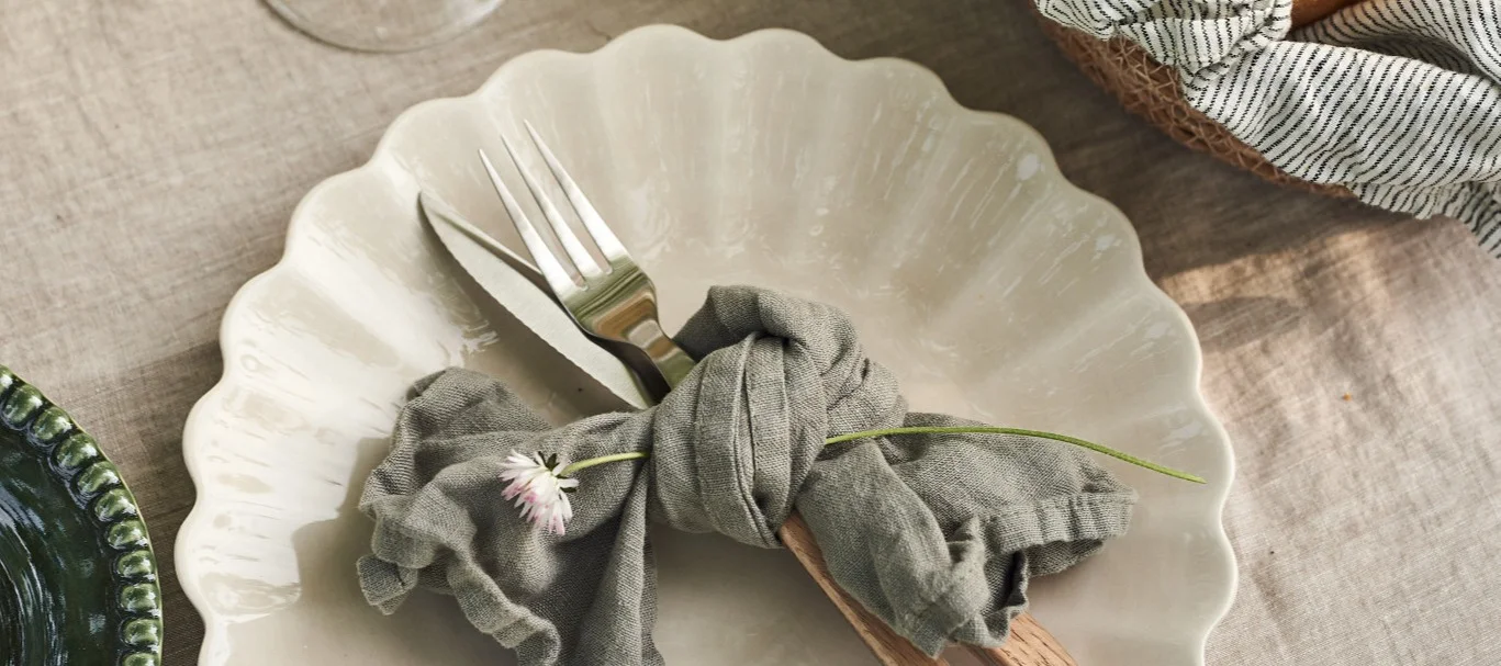 Decoración de la mesa de Midsummer: la decoración clásica de la mesa en Suecia es azul y blanca. Aquí puedes ver una gran mesa en el jardín con mantel blanco, vajilla azul y blanca y montones de pequeños jarrones con flores del prado.
