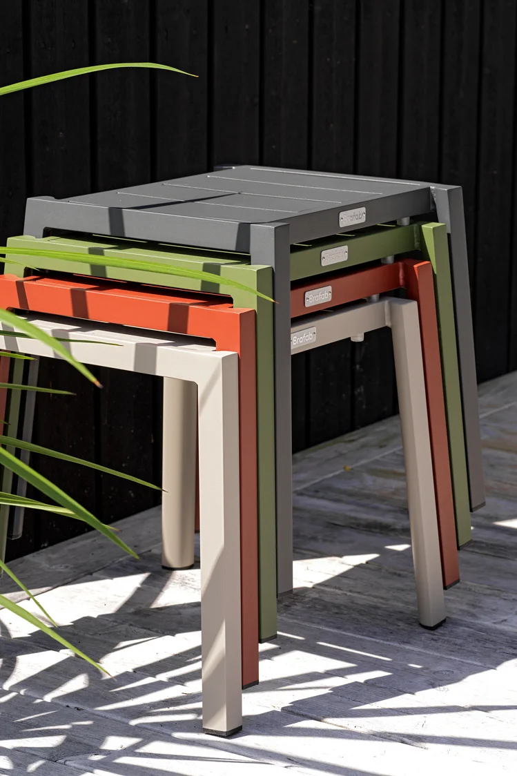 Las tendencias para muebles de jardín para 2025 también incluyen muebles multifuncionales. Los taburetes de la colección Delia de Brafab, que aquí se muestran apilados unos sobre otros en cuatro colores diferentes, ahorran espacio y son versátiles.