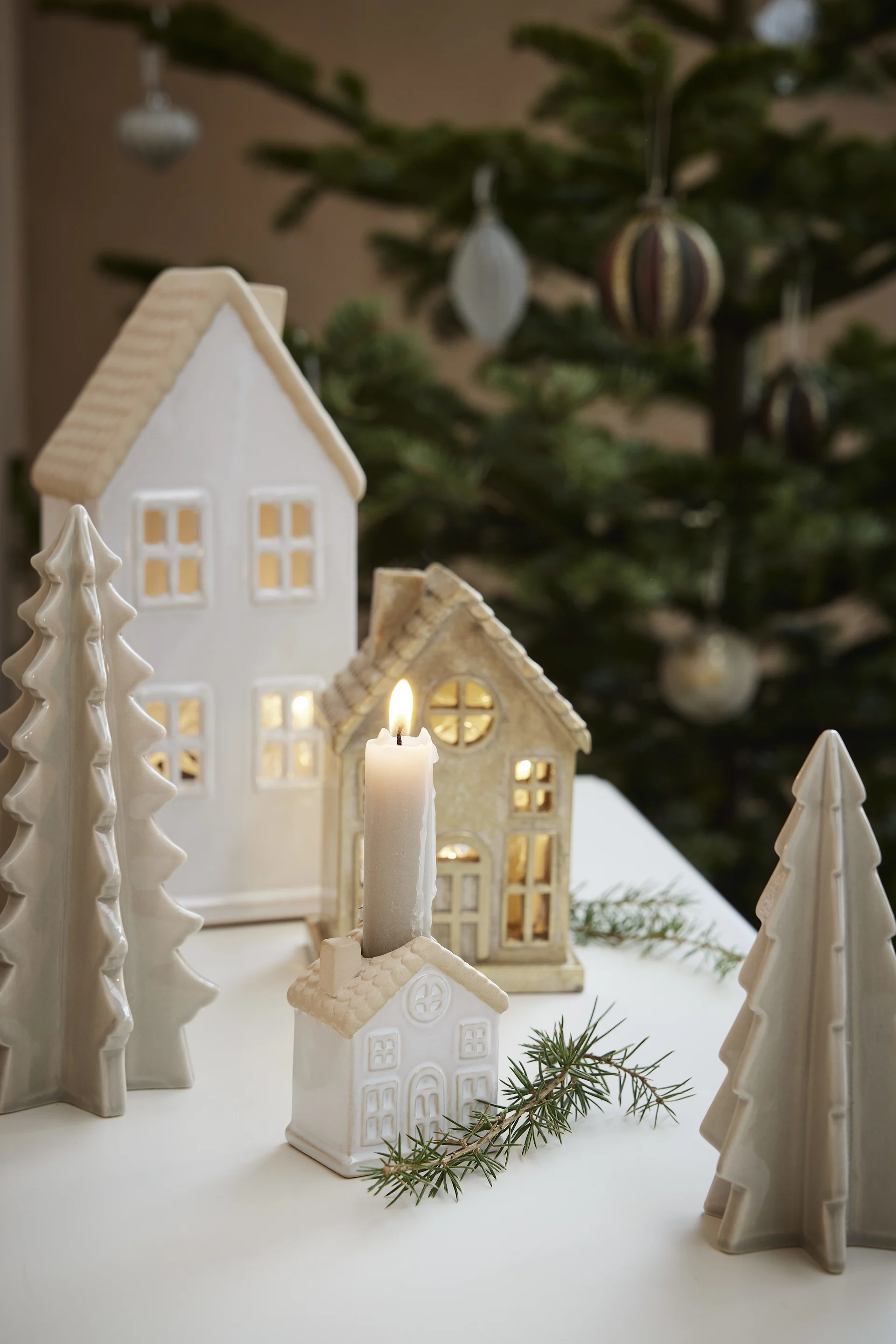 Decoración navideña escandinava: varias casitas luminosas de Lene Bjerre están sobre una mesa.