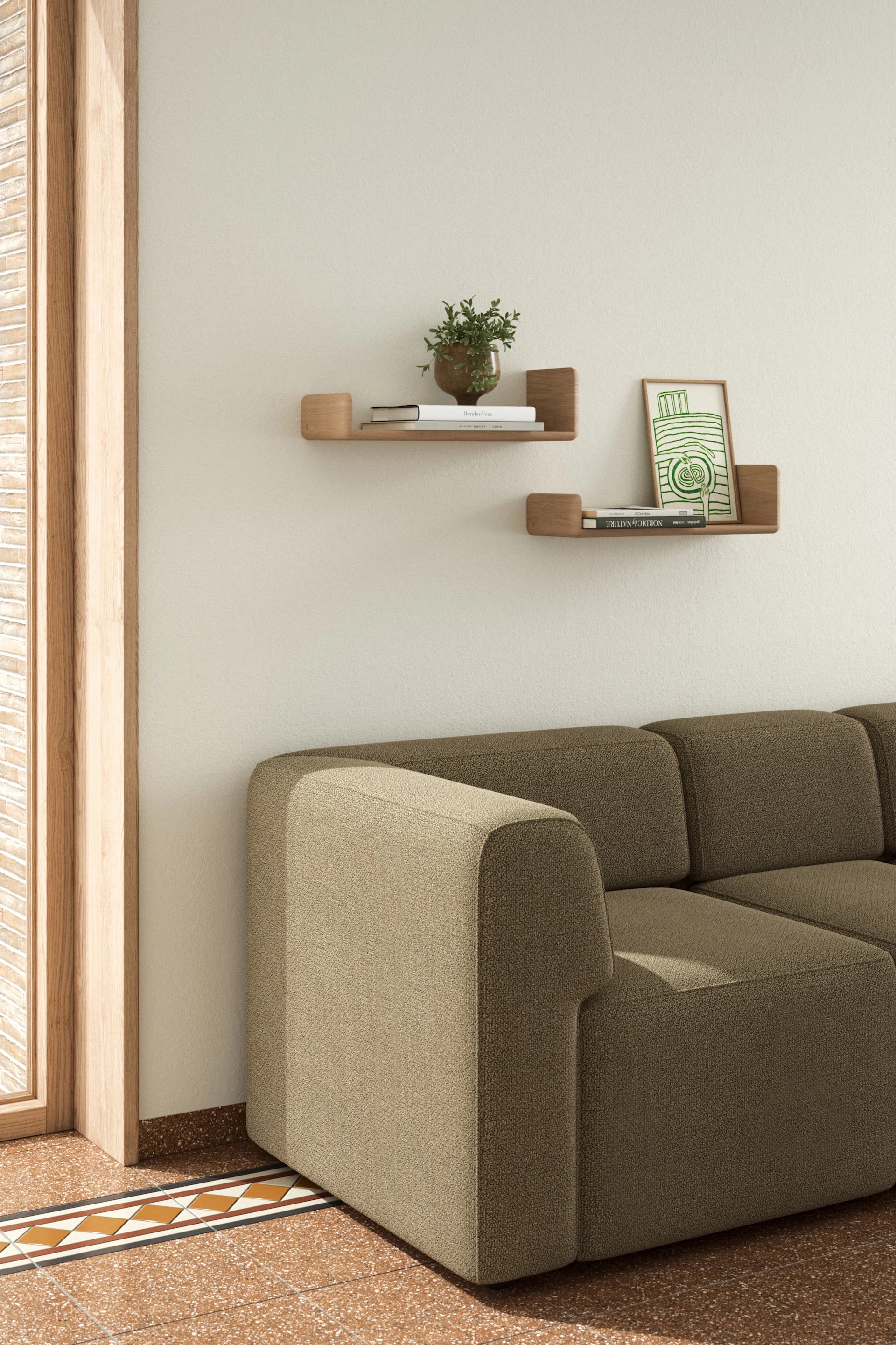 Una acogedora sala de estar con un sofá seccional beige, estantes de pared de madera con libros y una planta, y un suelo de baldosas con motivos.
