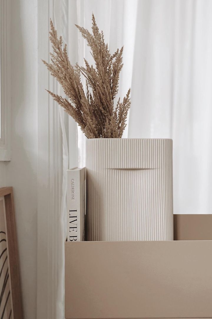 El estilo de vida Lagom también implica colores discretos. El jarrón Ridge de Muuto con flores secas en una jardinera beige de Ferm Living en casa de @beige_and_co.