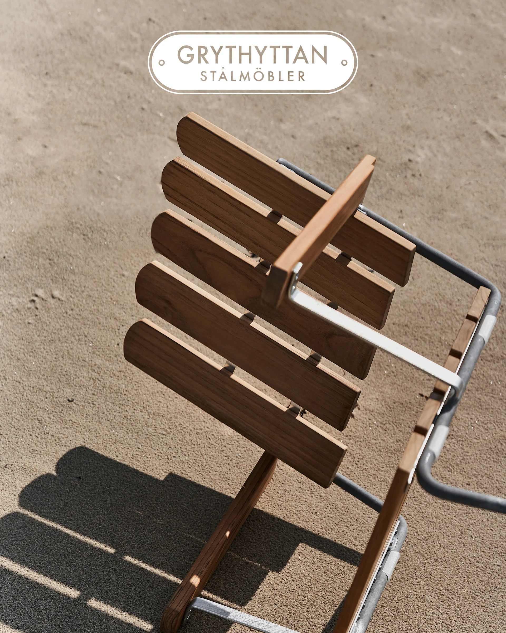 Silla de lamas de madera con estructura metálica sobre arena, vista desde arriba. Logotipo Grythyttan Stålmöbler.