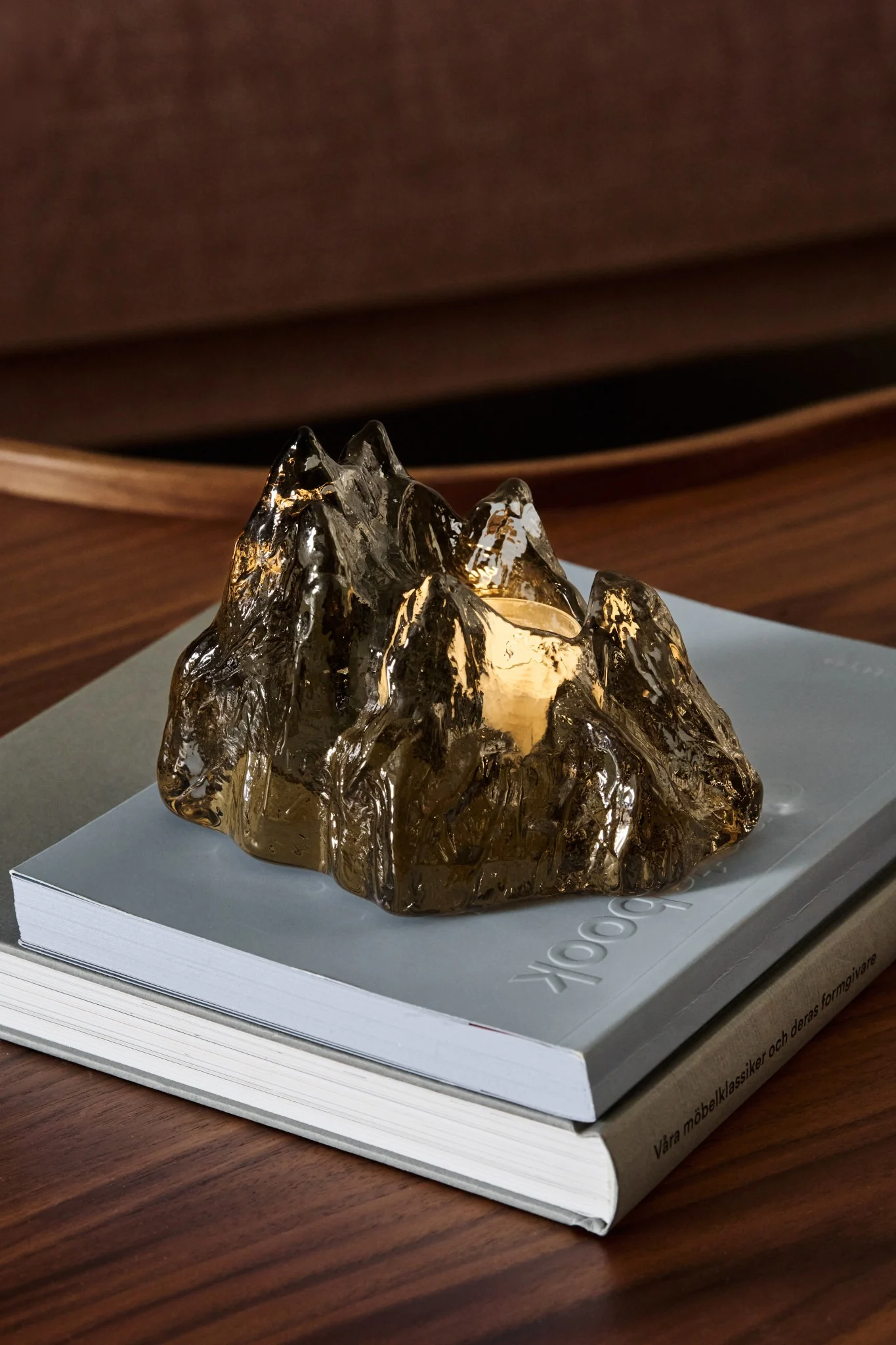 En un paquete de Nordic Nest aparece el portavelas marrón The Rock de Kosta Boda bajo el árbol de Navidad.