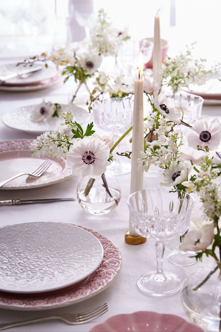 Decoración de mesa en blanco y rosa, platos de la colección Lace de Mateus, elegantes copas, velas y flores.