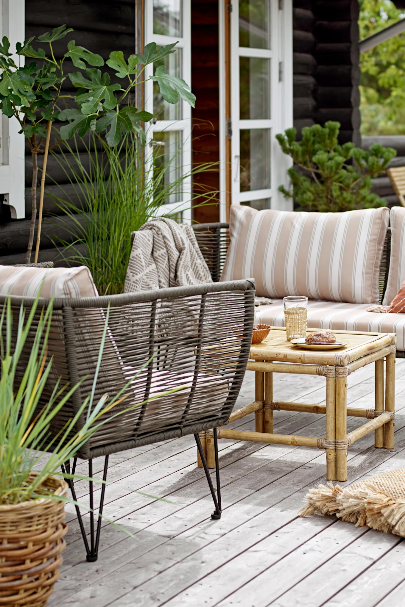 Decora un balcón boho con el sofá Mundo de Bloomingville, que se coloca junto con el sillón a juego en el balcón.