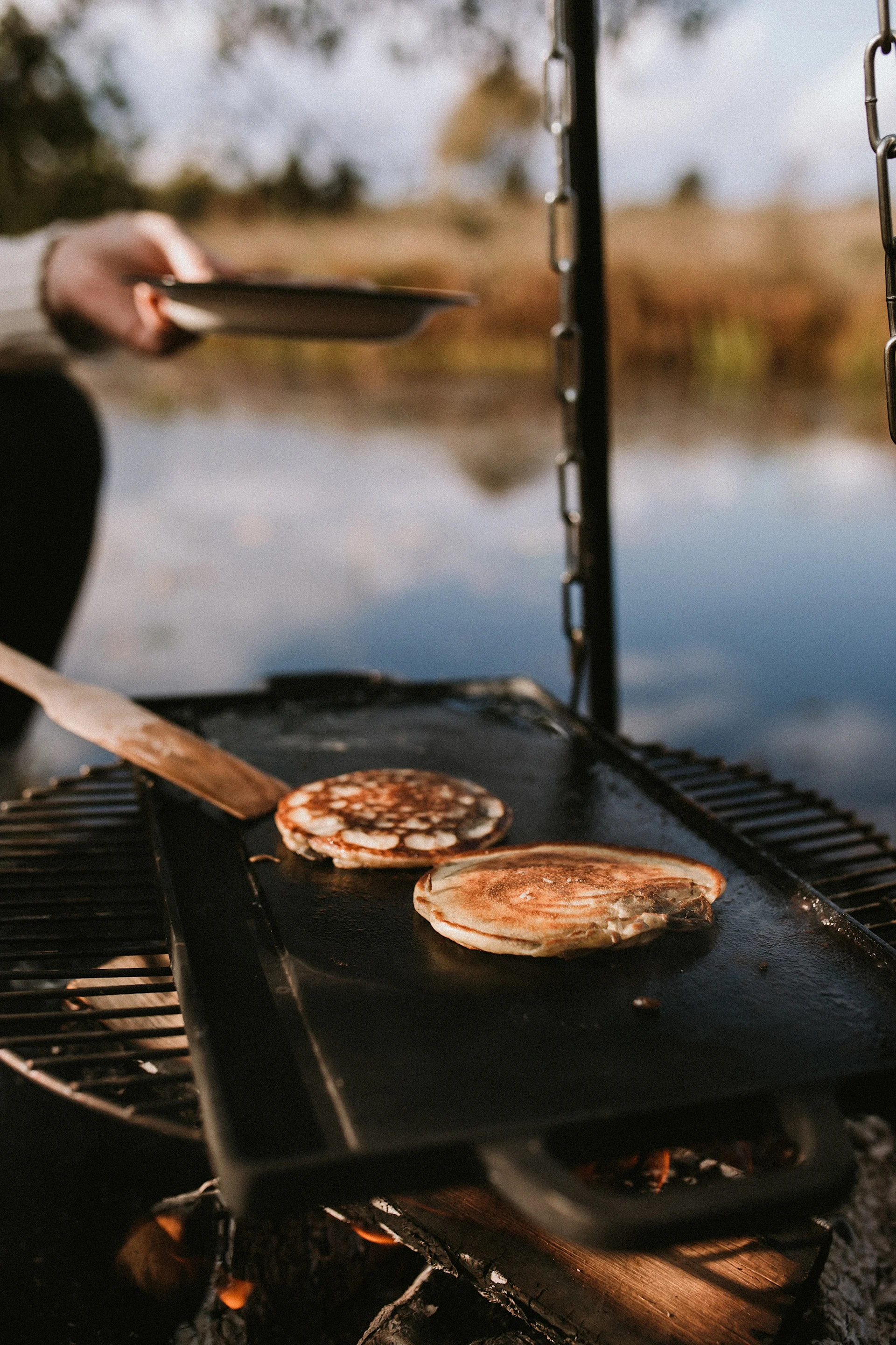 Cocinar al aire libre en el jardín es la tendencia en 2025, por ejemplo en una barbacoa con la mesa de asar Satake, en la que aquí se hornean tortitas.