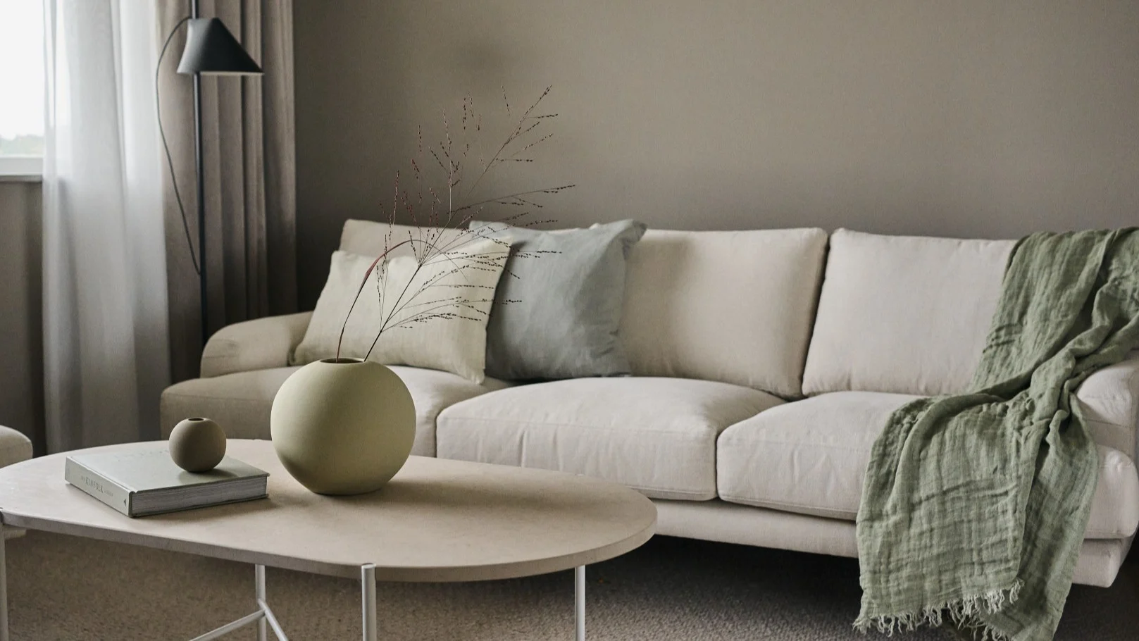 Dos versiones del jarrón Ball de Cooee Design sobre una mesa de centro en un salón escandinavo.